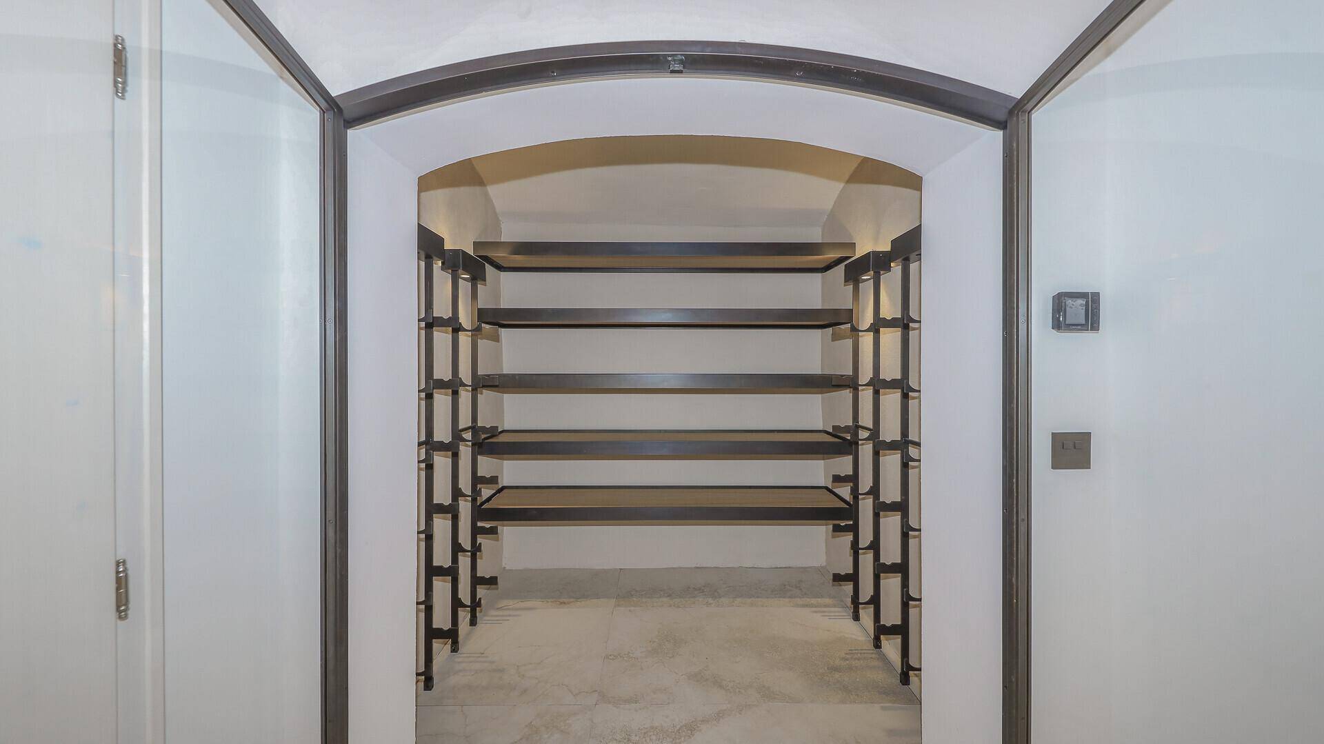 Weinkeller mit Regalen für Flaschenlagerung und gewölbter Decke.