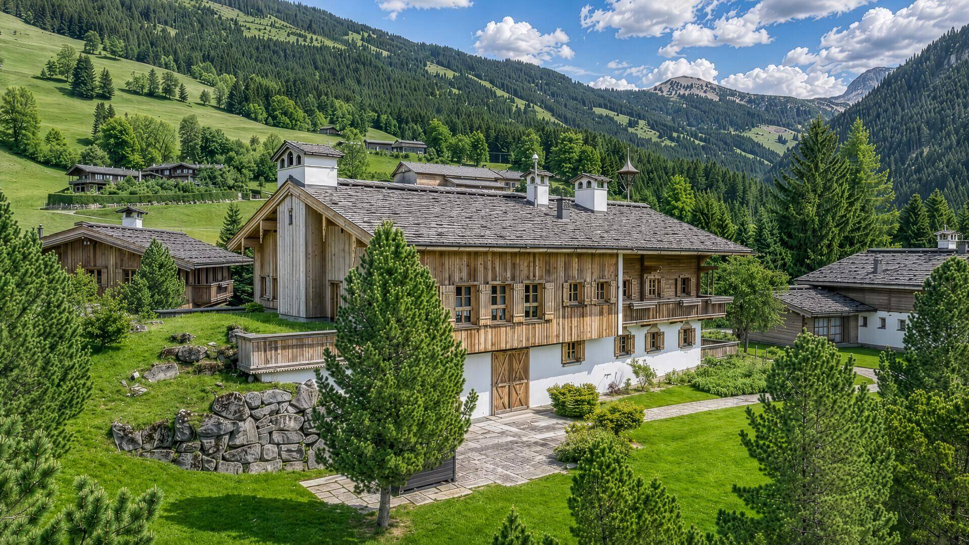Charmantes Holzchalet mit Steinfassade und gepflegtem Gartenbereich in alpiner Umgebung.