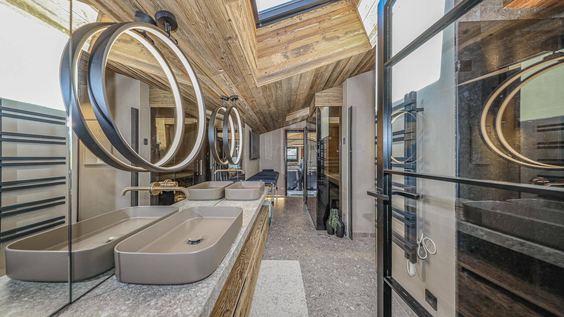 Modernes Badezimmer mit Doppelwaschbecken, großen Spiegeln und Holzbalkendecke.