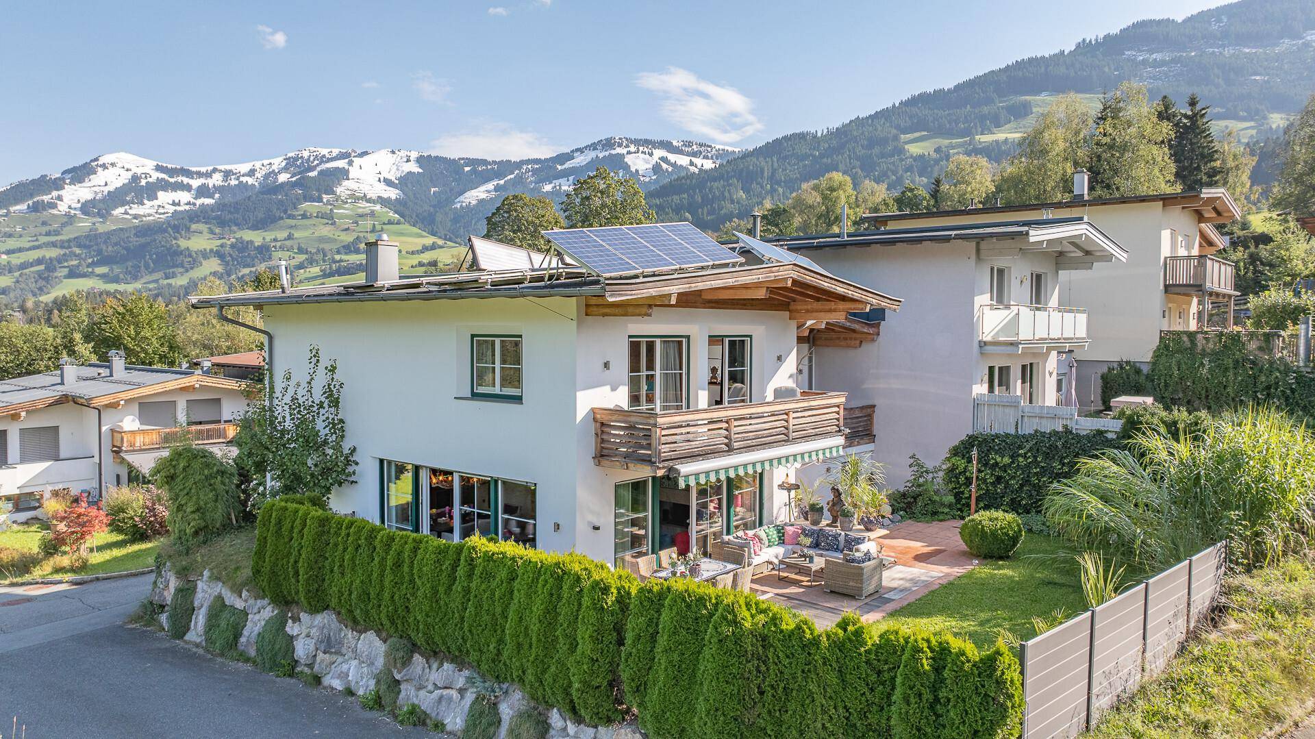 Charmantes Haus mit Solaranlage und Terrasse, eingebettet in eine malerische Berglandschaft.