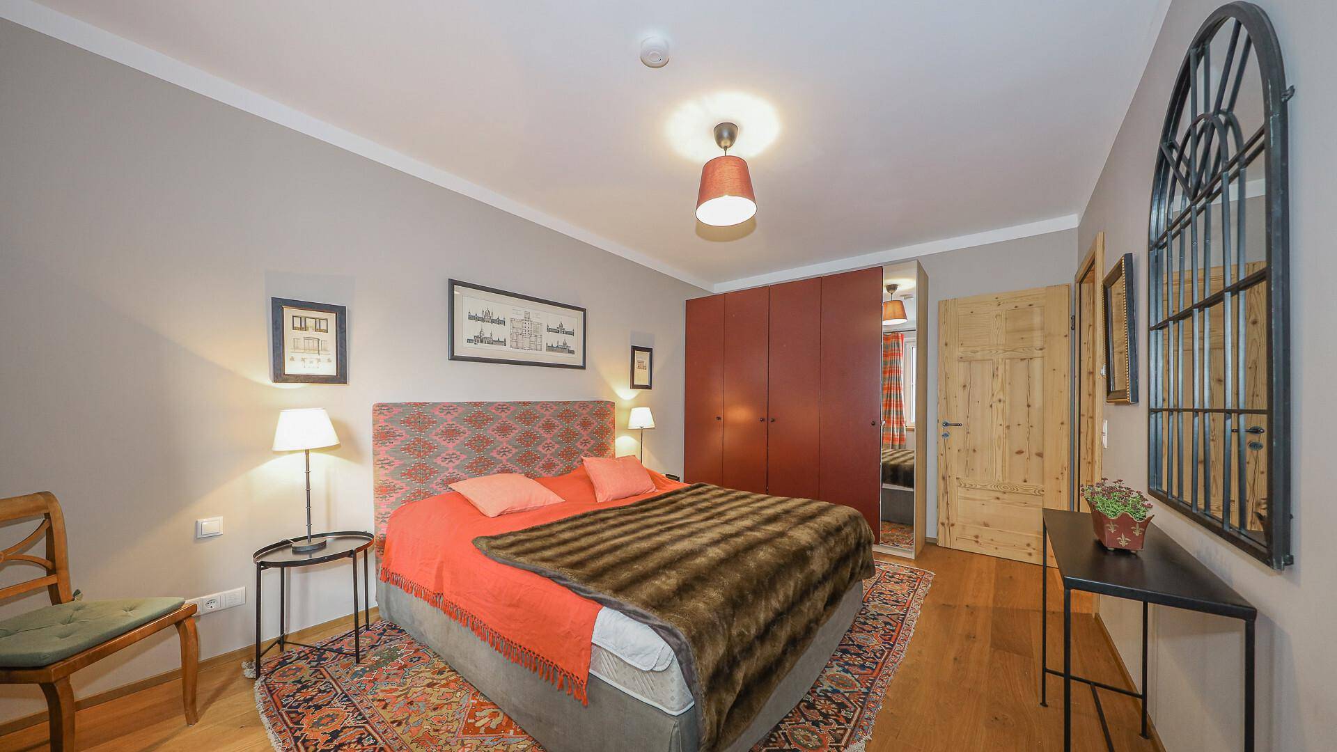 Schlafzimmer mit Doppelbett, Holzboden und integrierten Kleiderschränken für Stauraum.