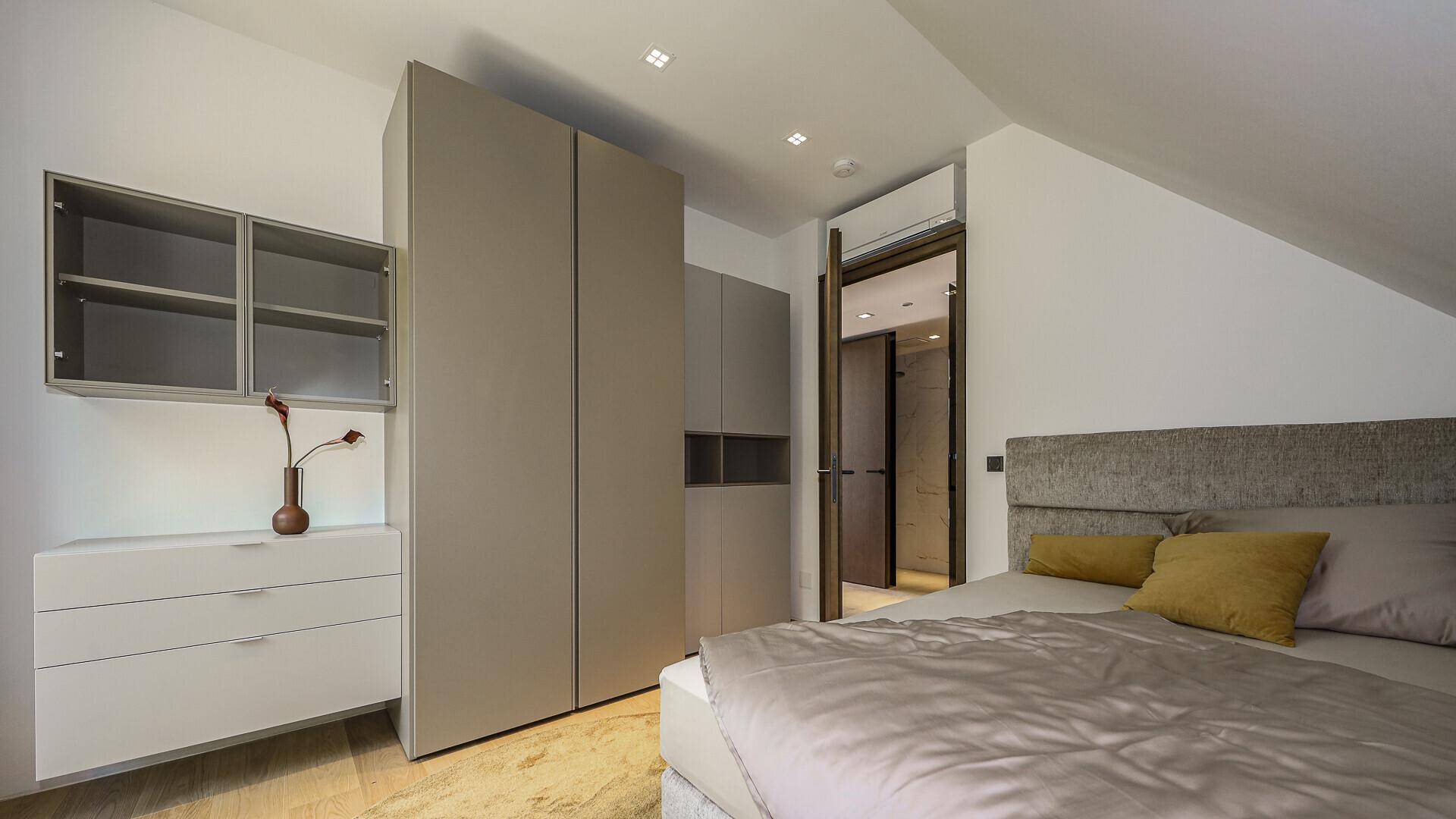 Schlafzimmer im Dachgeschoss mit Einbauschränken und modernem Design.