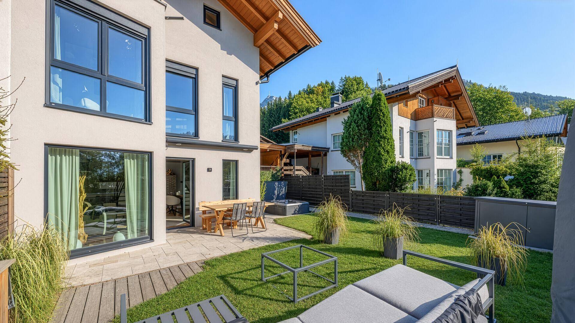 Attraktive Hausfassade mit direktem Zugang zu einem gepflegten Garten und einer einladenden Terrasse.