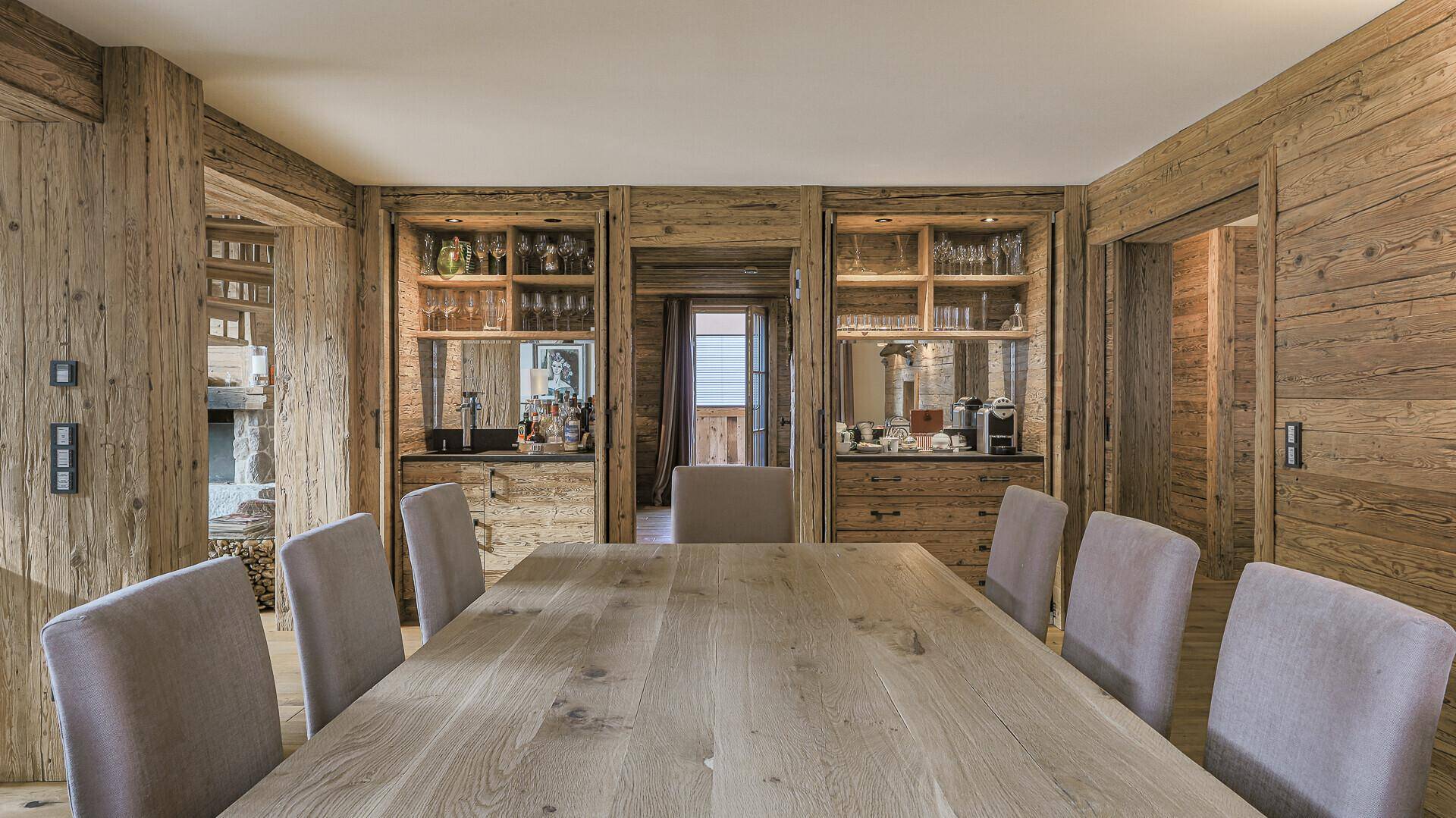 Esszimmer mit Holztisch, bequemen Stühlen und integrierten Schränken im Alpenstil.