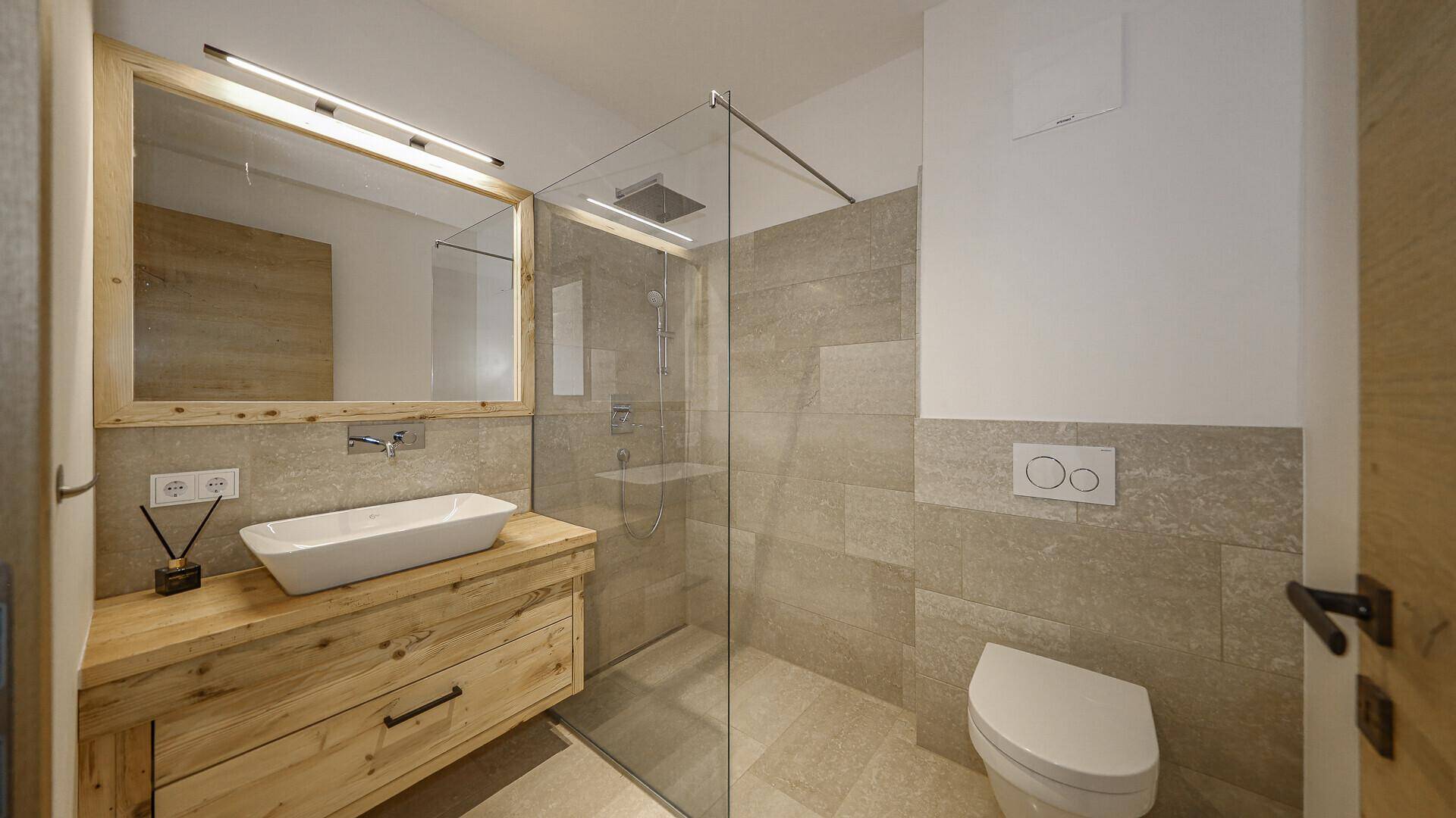 Modernes Badezimmer mit begehbarer Dusche, Holzwaschtisch und Wand-WC.
