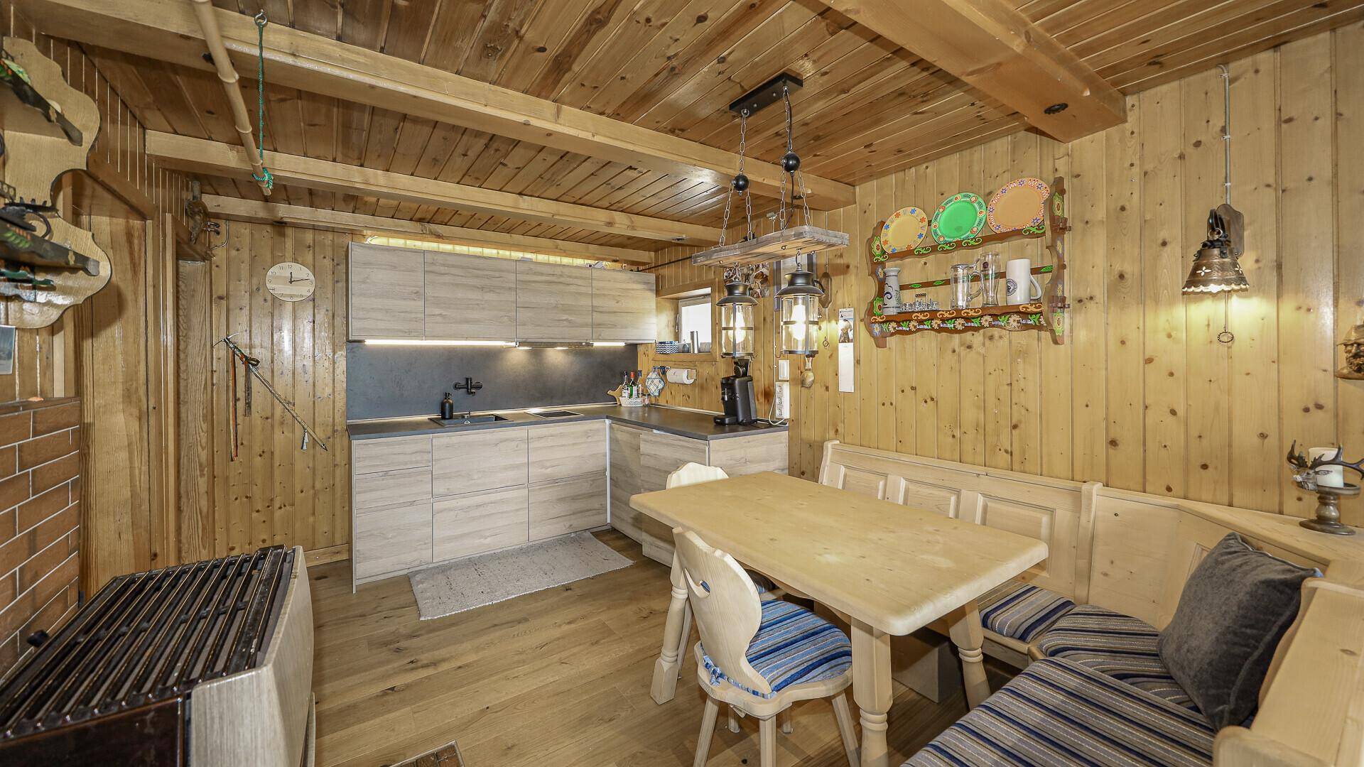 Moderne Küchenzeile mit Holztisch und Sitzbank in rustikalem Ambiente mit Holztäfelung.