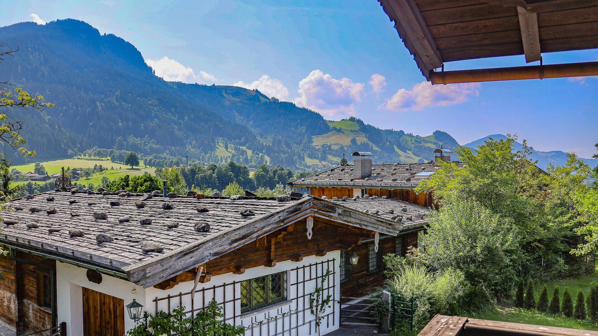 Panoramablick über traditionelle Dächer und die sanften Hügel der Berglandschaft.