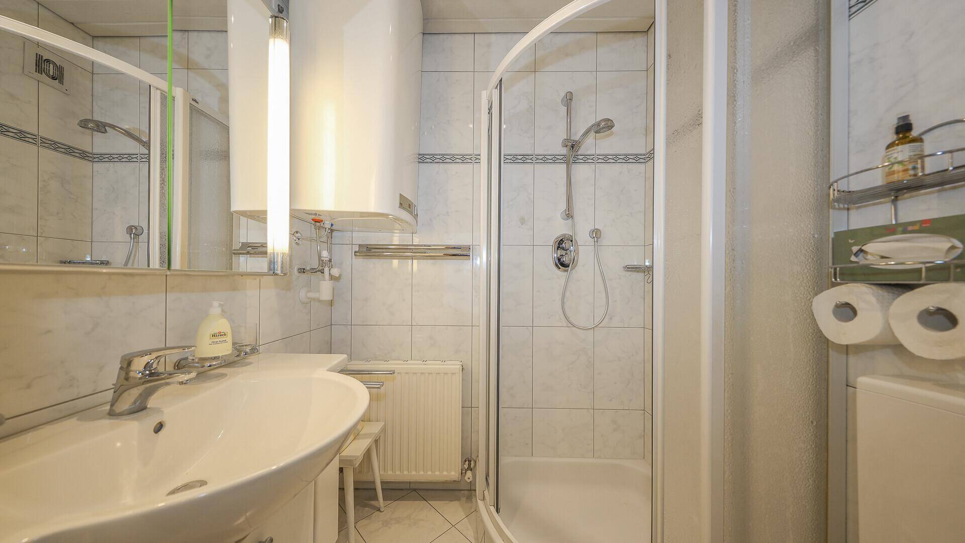 Helles Badezimmer im traditionellen Stil mit weißen Fliesen, Einzelwaschbecken und Duschkabine.