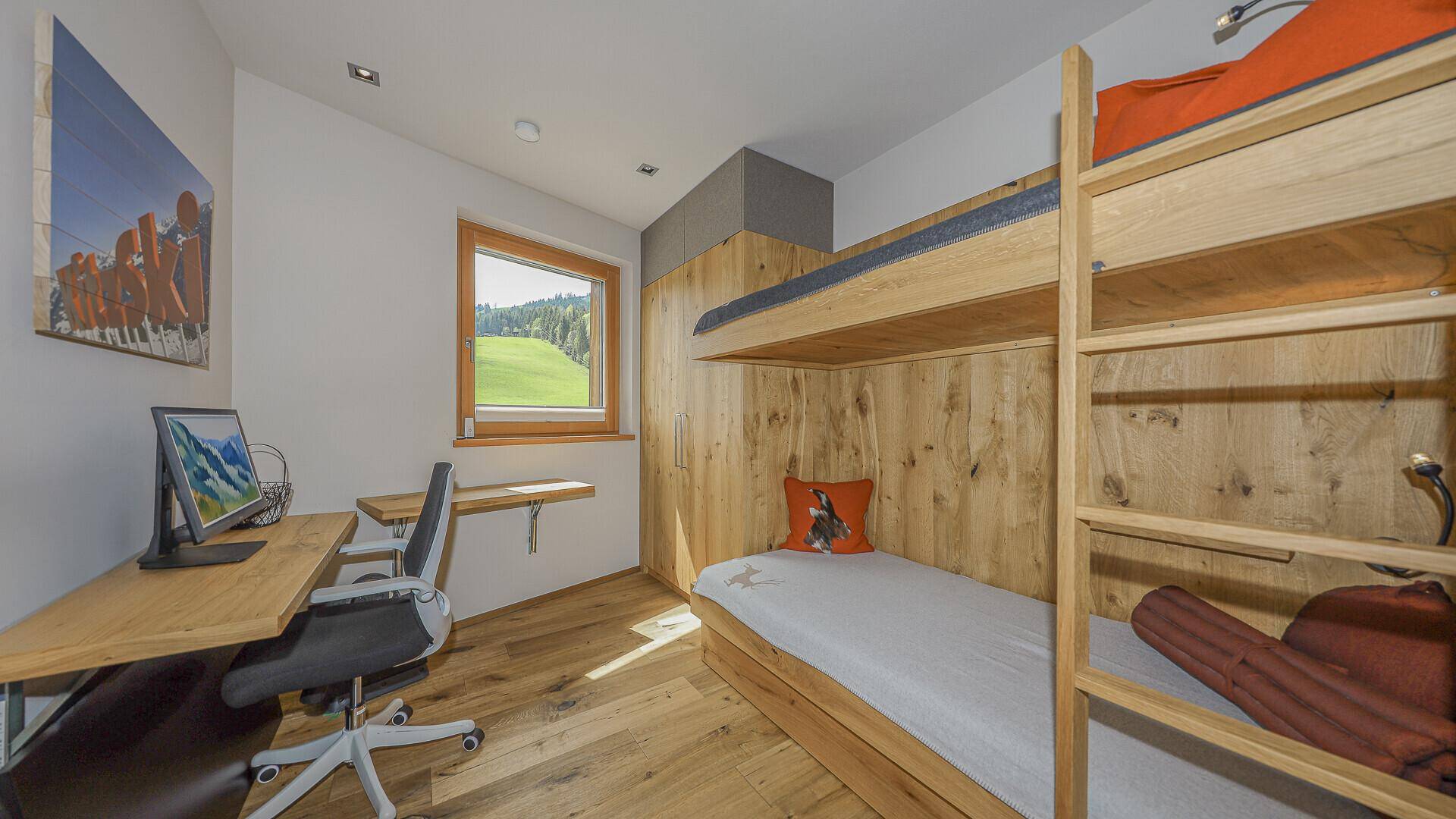 Kinderzimmer mit Etagenbett, Schreibtisch und Blick ins Grüne.