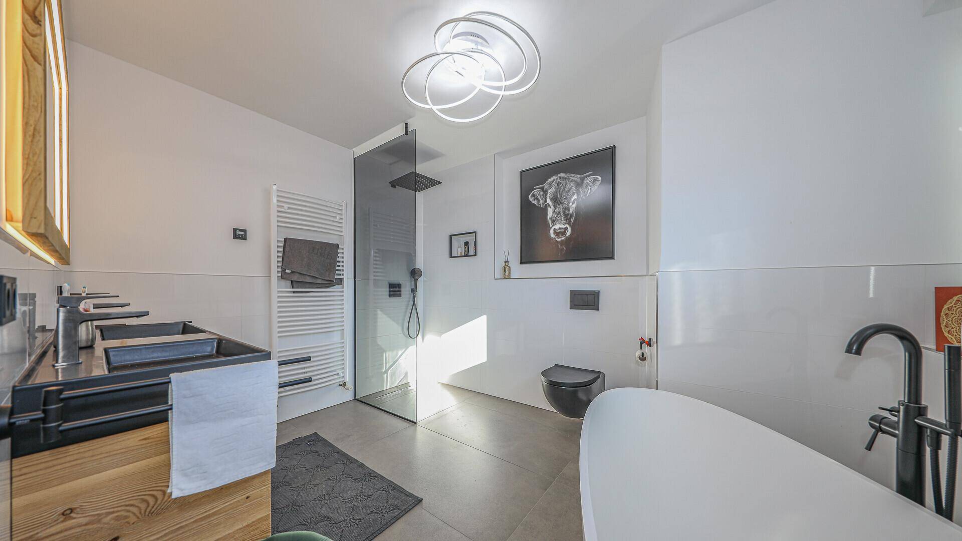 Modernes Badezimmer mit freistehender Badewanne, begehbarer Dusche und Doppelwaschbecken in elegantem Design.