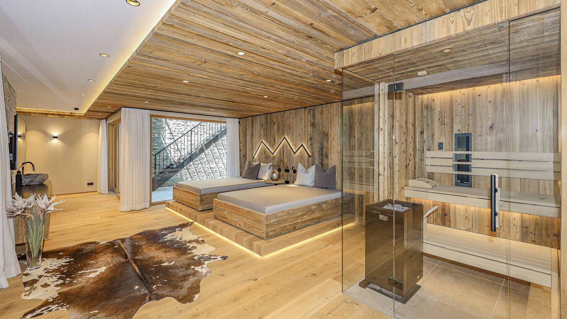 Exklusiver Wellnessbereich mit Sauna, zwei Liegeflächen und Holzelementen für pure Entspannung.