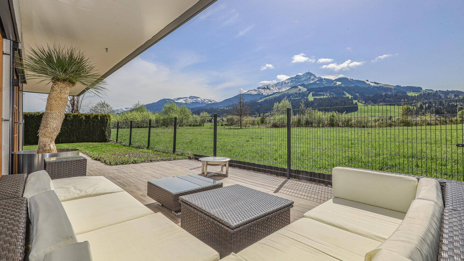 Großzügige Terrasse mit bequemen Loungemöbeln und weitem Blick auf die umliegende Berglandschaft.