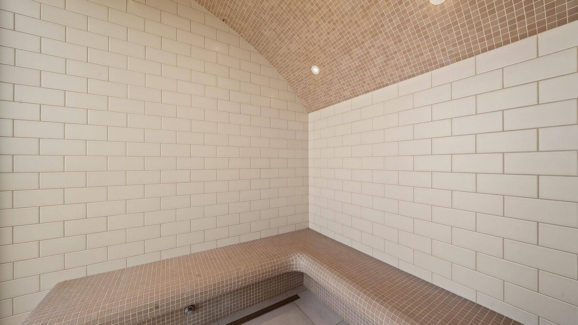 Entspannungsbereich mit gefliesten Bänken und gewölbter Decke, ideal für Wellnessanwendungen.