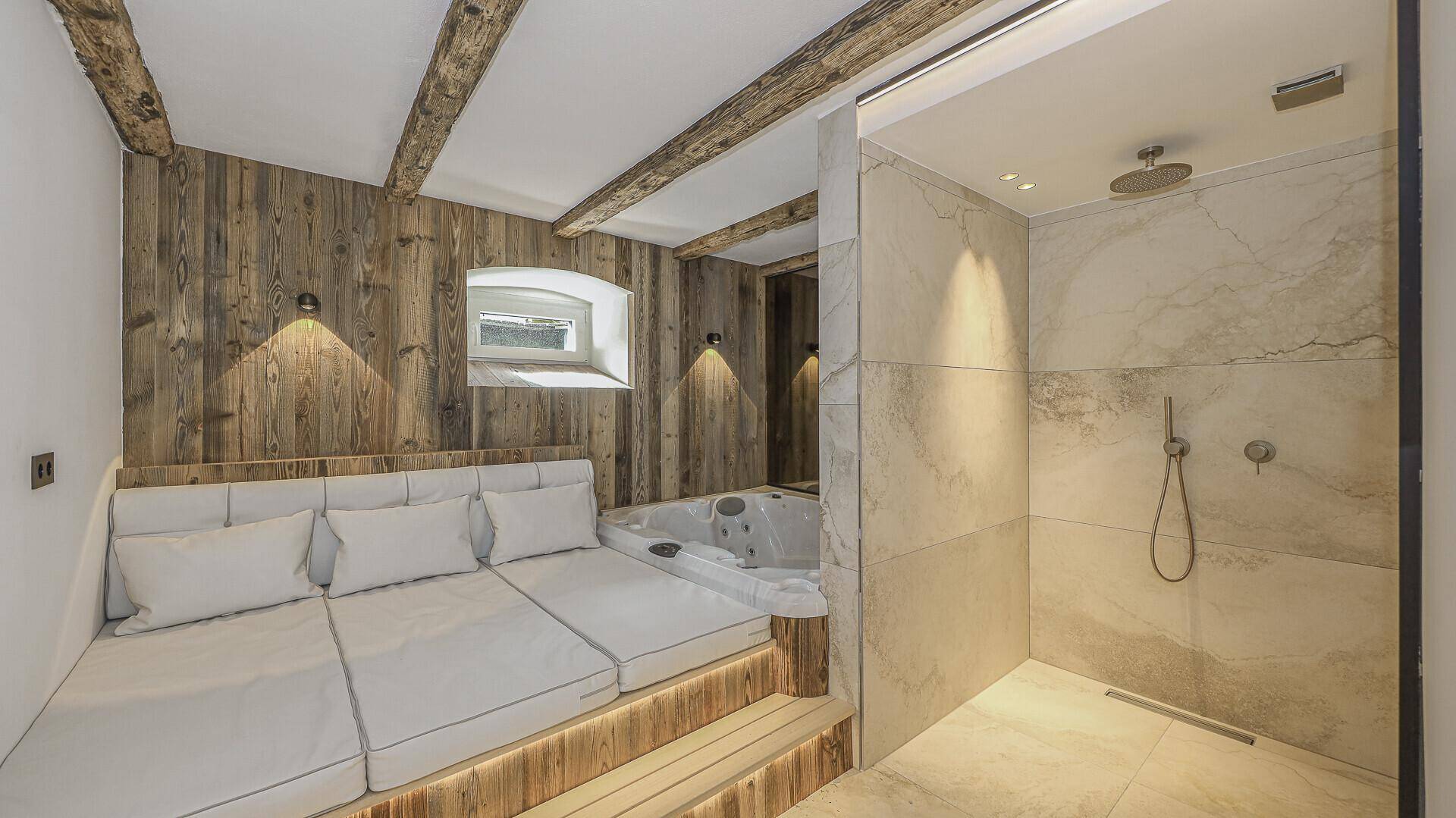 Wellnessbereich mit Whirlpool, begehbarer Dusche und Holzwänden.