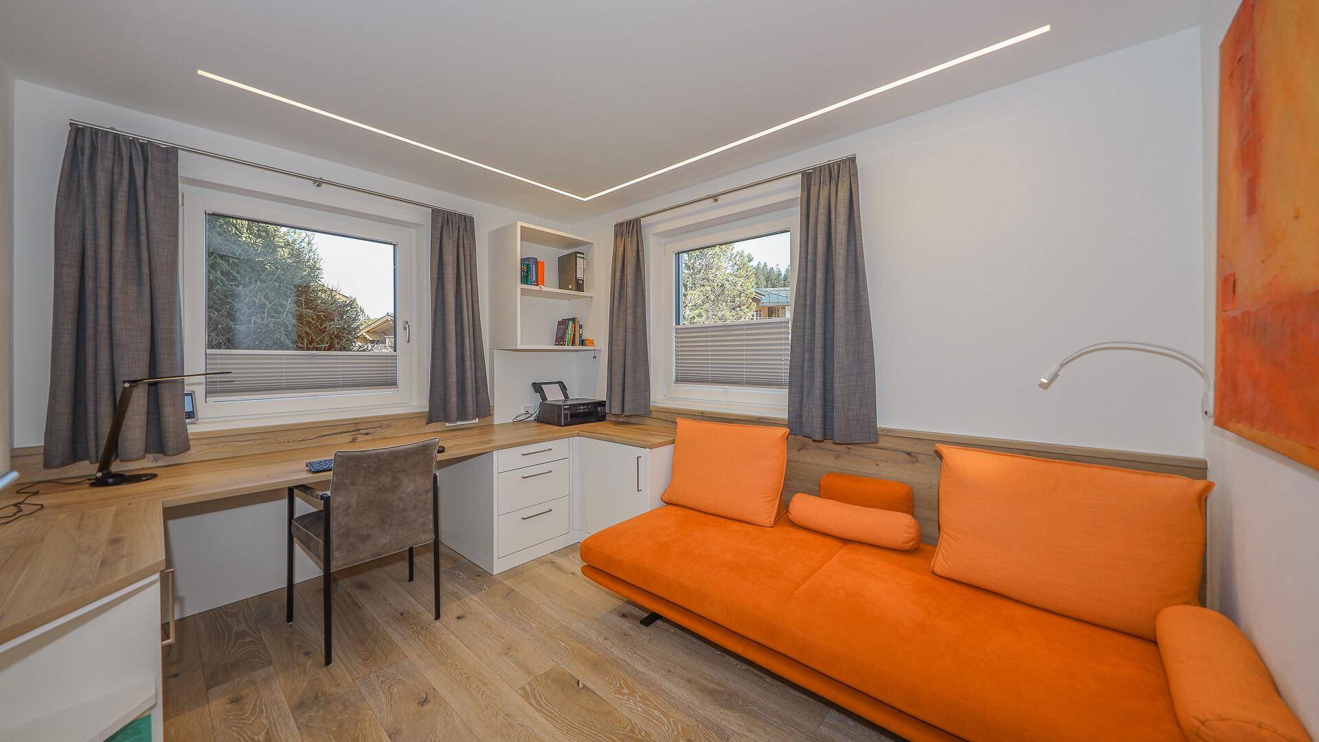 Funktionales Büro mit Schreibtisch, Stauraum und bequemer Sitzgelegenheit in Orange.