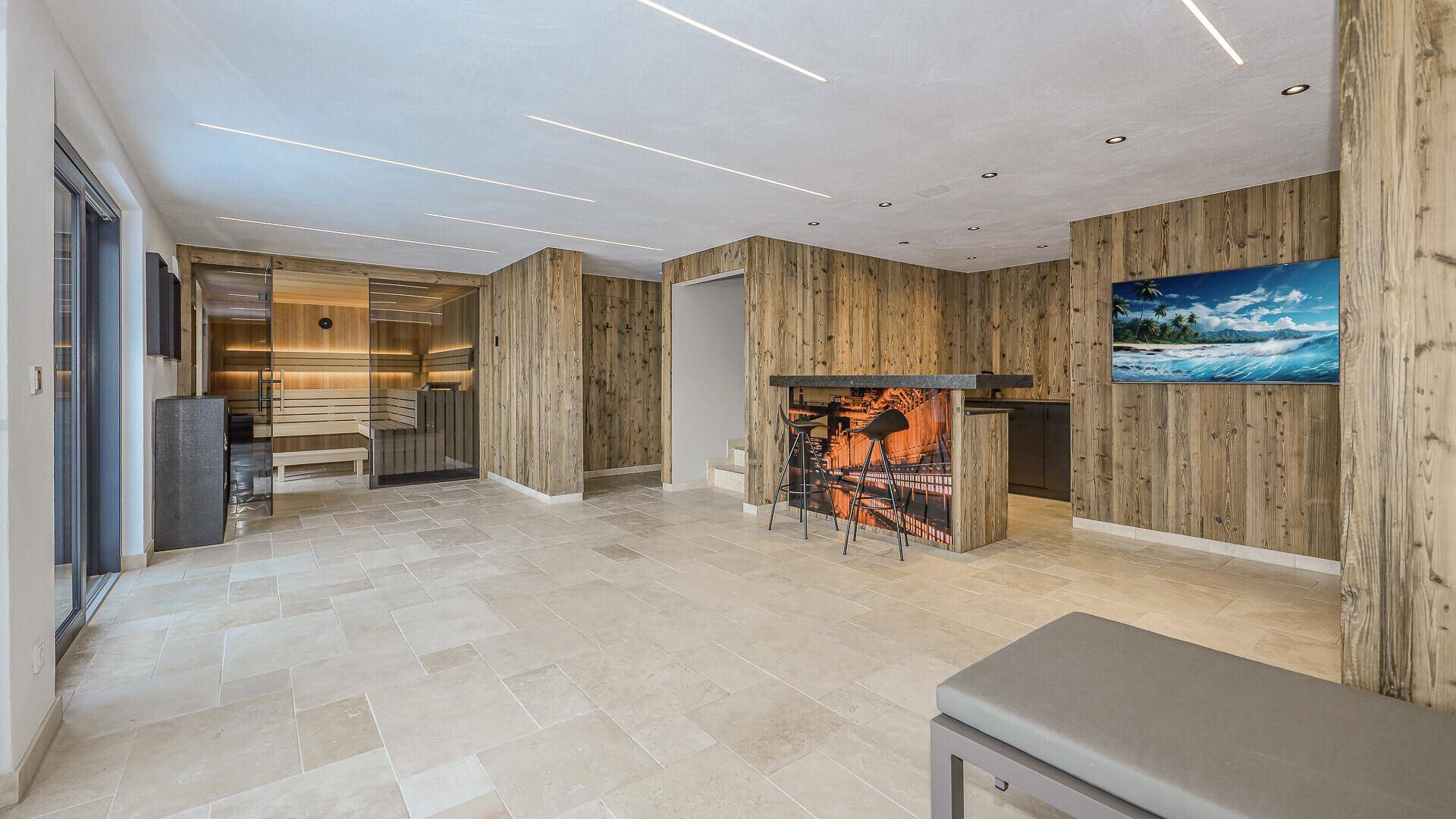 Großer Wellnessbereich mit Bar, Fliesenboden und integrierter Sauna für Entspannung.
