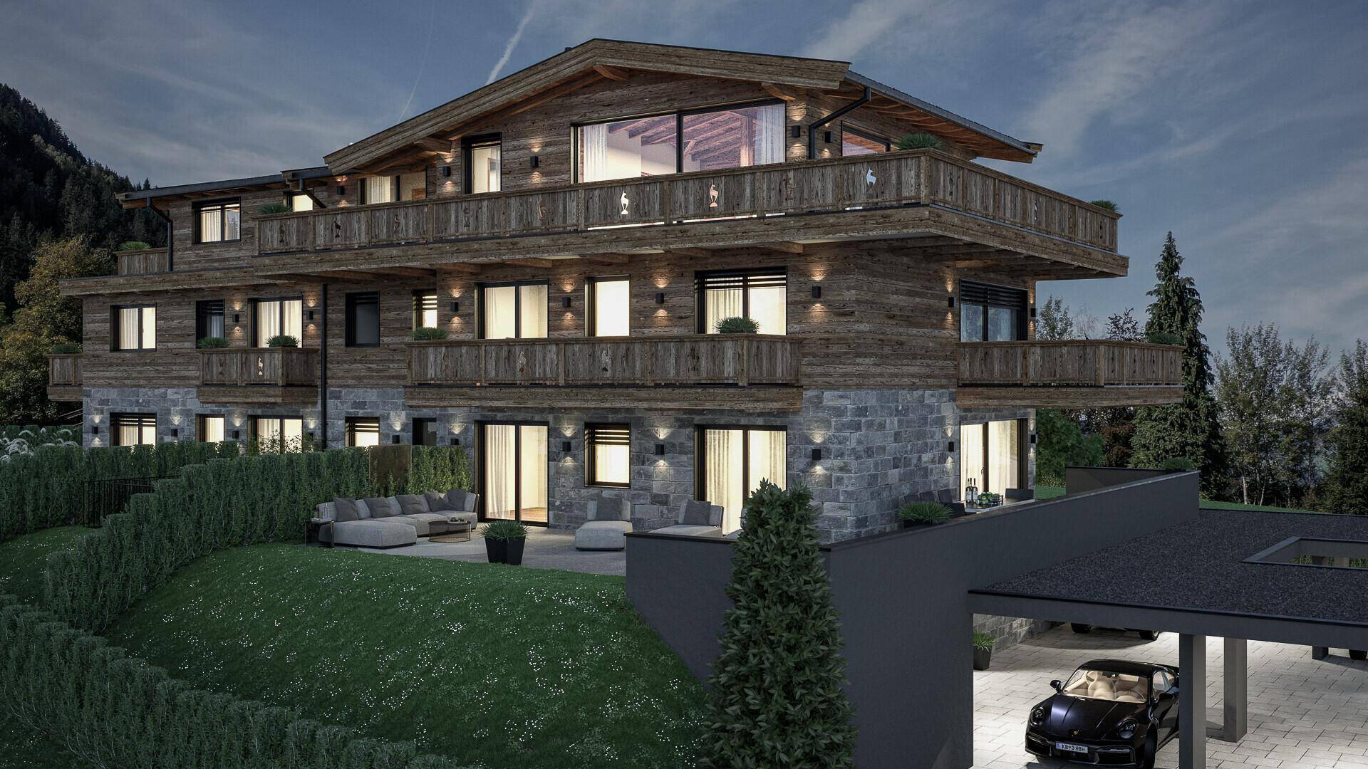 Beleuchtetes Chalet bei Dämmerung mit Holzfassade, Steinelementen und Carports in den Bergen.