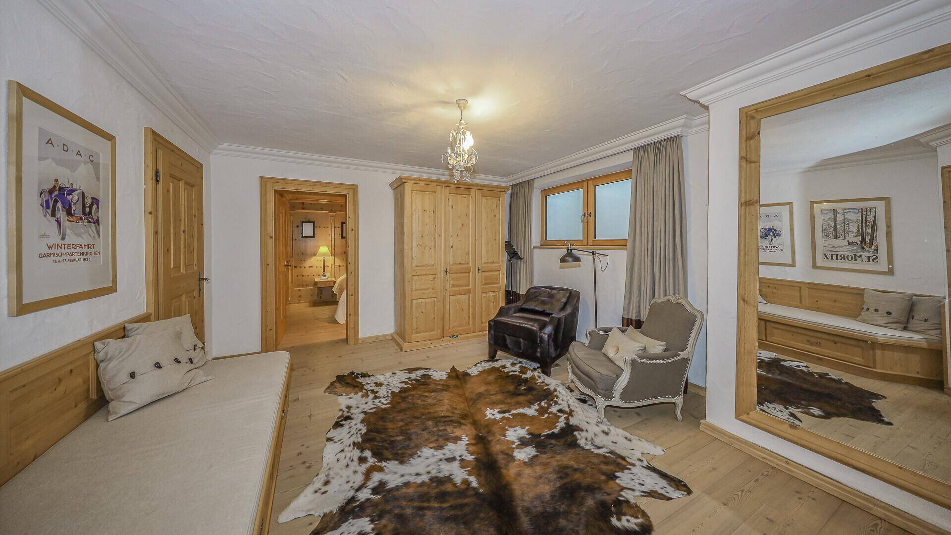 Geräumiges Schlafzimmer mit Holzboden, Tagesbett und Zugang zur Sauna.