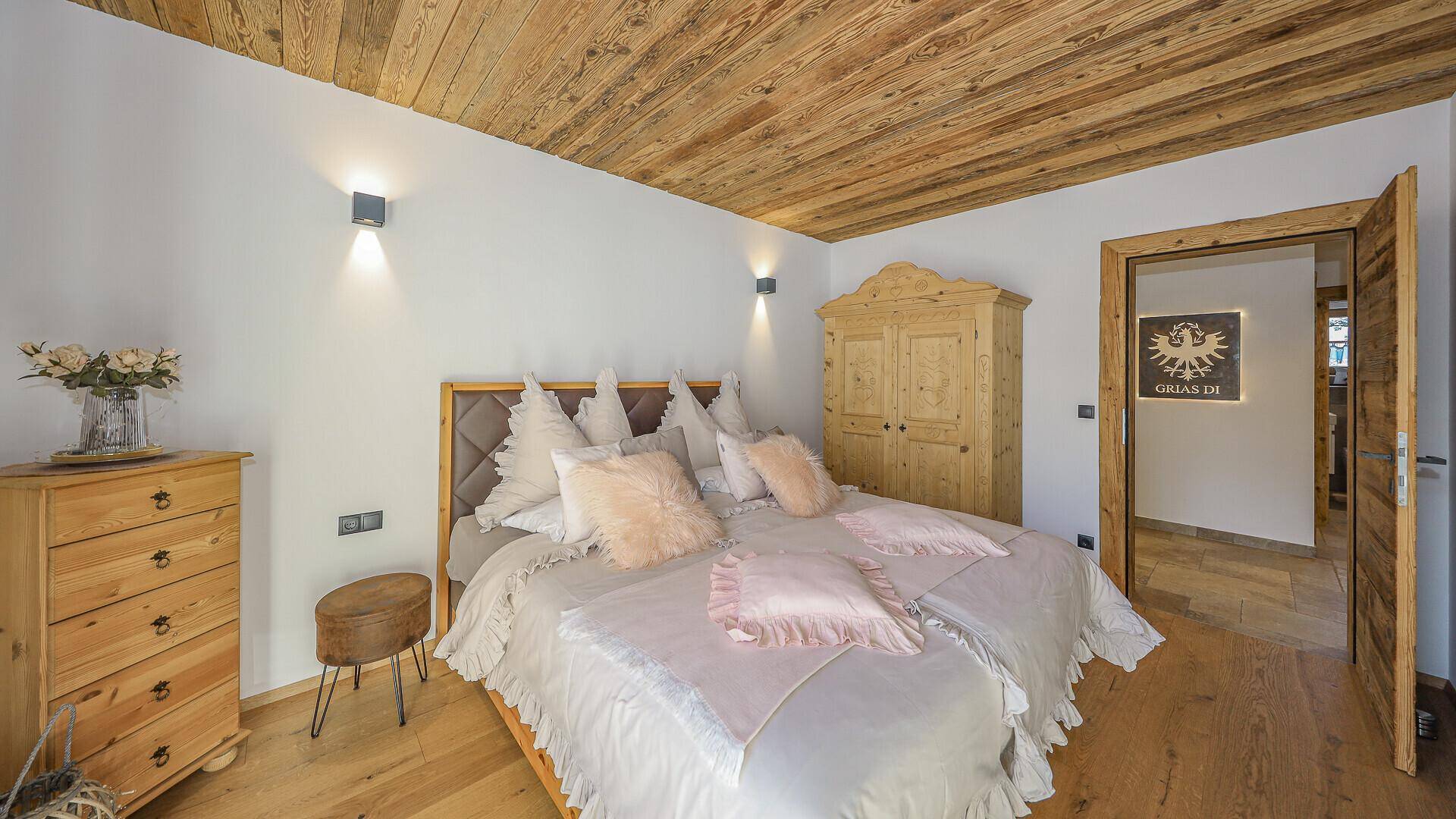 Gemütliches Schlafzimmer mit Holzdecke, traditionellem Kleiderschrank und hellem Ambiente.