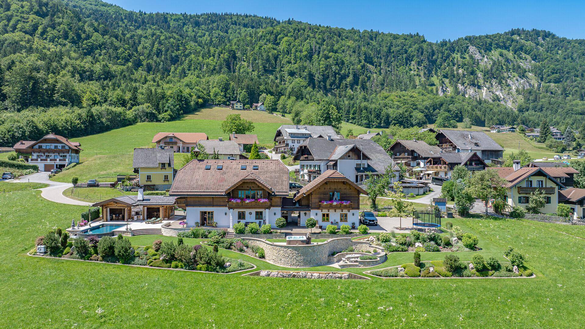 Luftaufnahme eines weitläufigen Anwesens mit Pool, Whirlpool und gepflegter Gartenanlage.