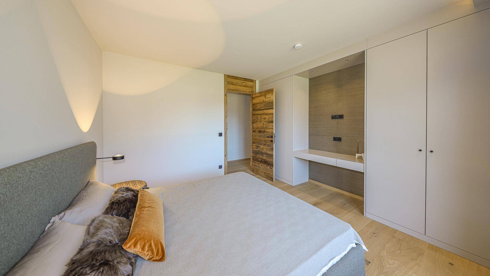 Geräumiges Schlafzimmer mit Einbauschränken, Holzboden und moderner Beleuchtung.