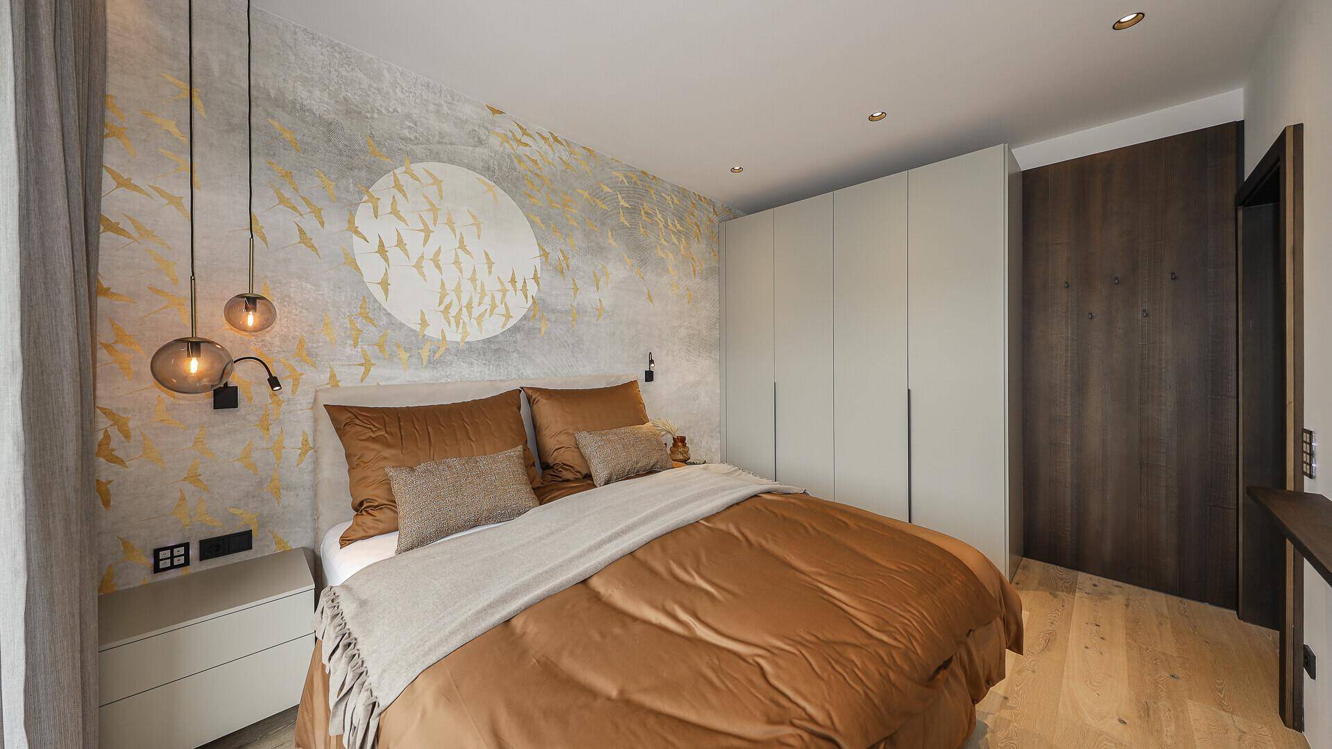 Modernes Schlafzimmer mit Einbauschränken, Holzboden und dekorativer Wandgestaltung.