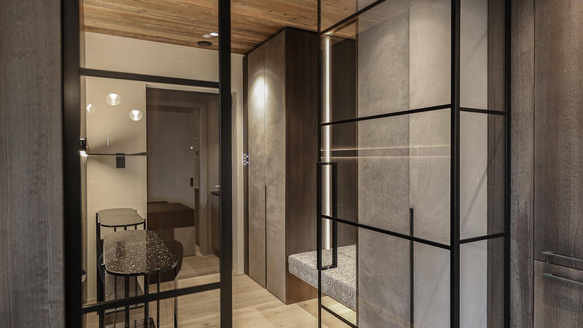 Moderner Flur mit integrierten Schränken und Sitzgelegenheit, Blick zum Badezimmer.