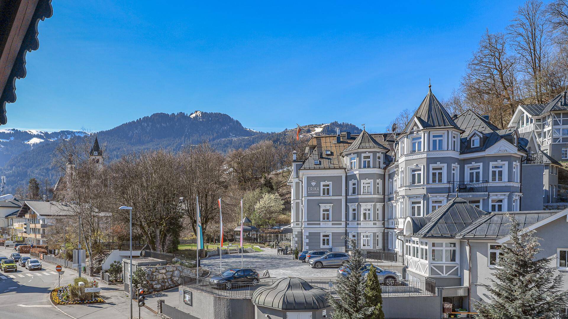 Panoramablick auf die charmante Stadtarchitektur und die majestätischen Berge unter einem klaren blauen Himmel.