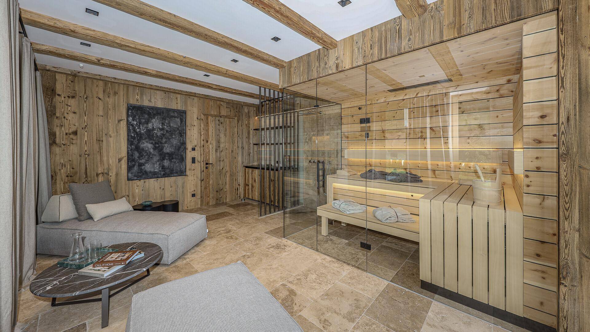 Moderner Wellnessbereich mit Holzsauna, Entspannungsliegen und stilvoller Einrichtung.