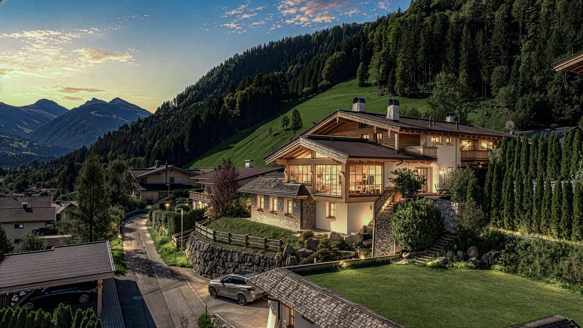 Alpenhaus in idyllischer Berglandschaft bei Sonnenuntergang, umgeben von grünen Hügeln.