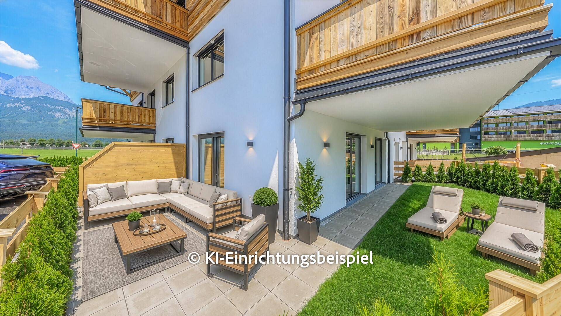 Möblierte Terrasse mit Lounge-Möbeln, Rasen und Bergblick.