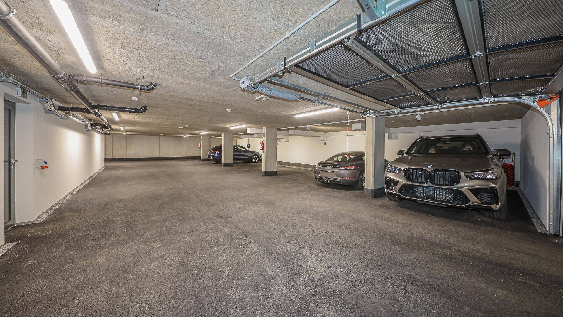 Helle Tiefgarage mit mehreren Stellplätzen und modernen Beleuchtungssystemen.