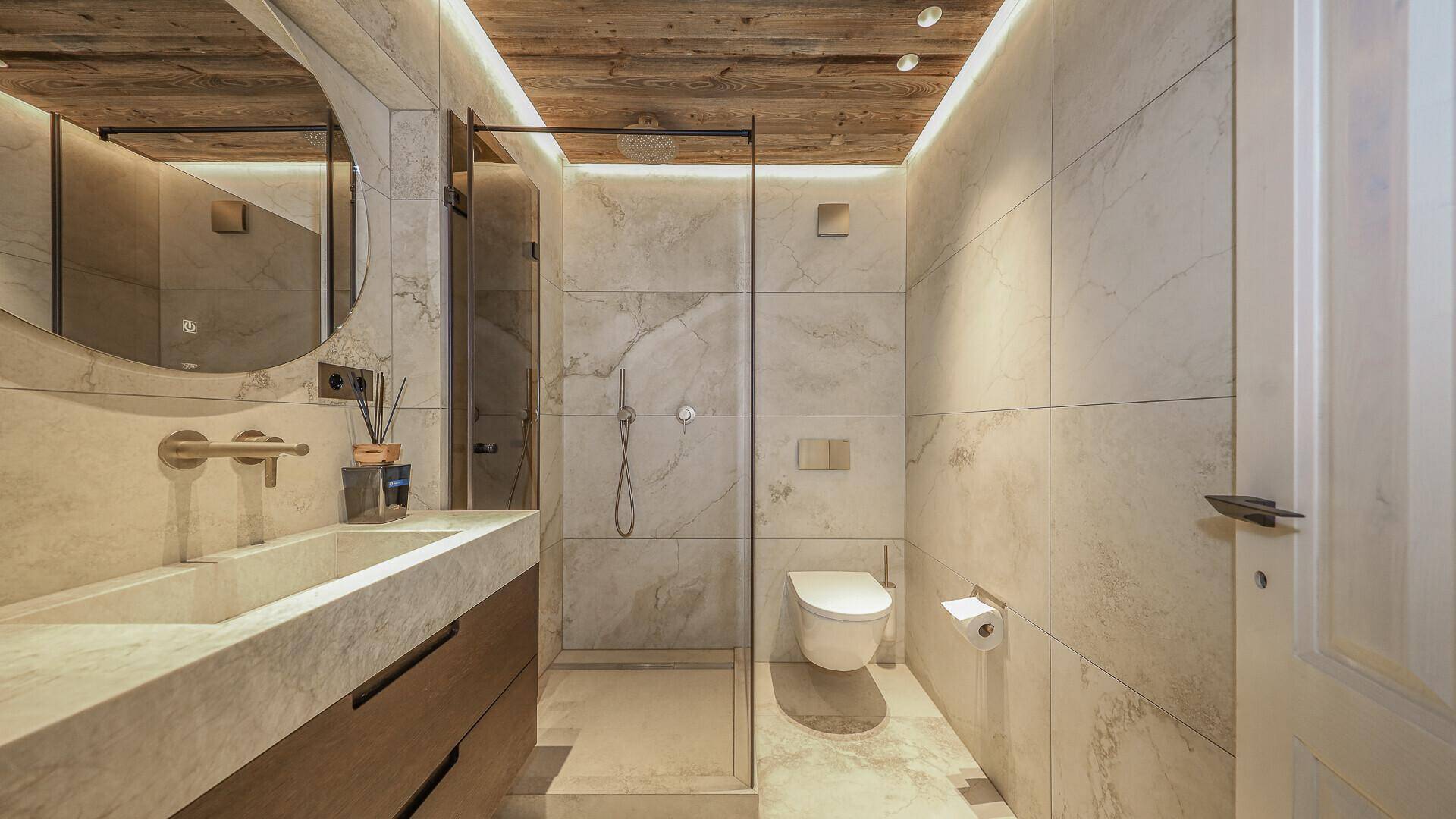 Modernes Badezimmer mit begehbarer Dusche, Wand-WC und Marmorfliesen.