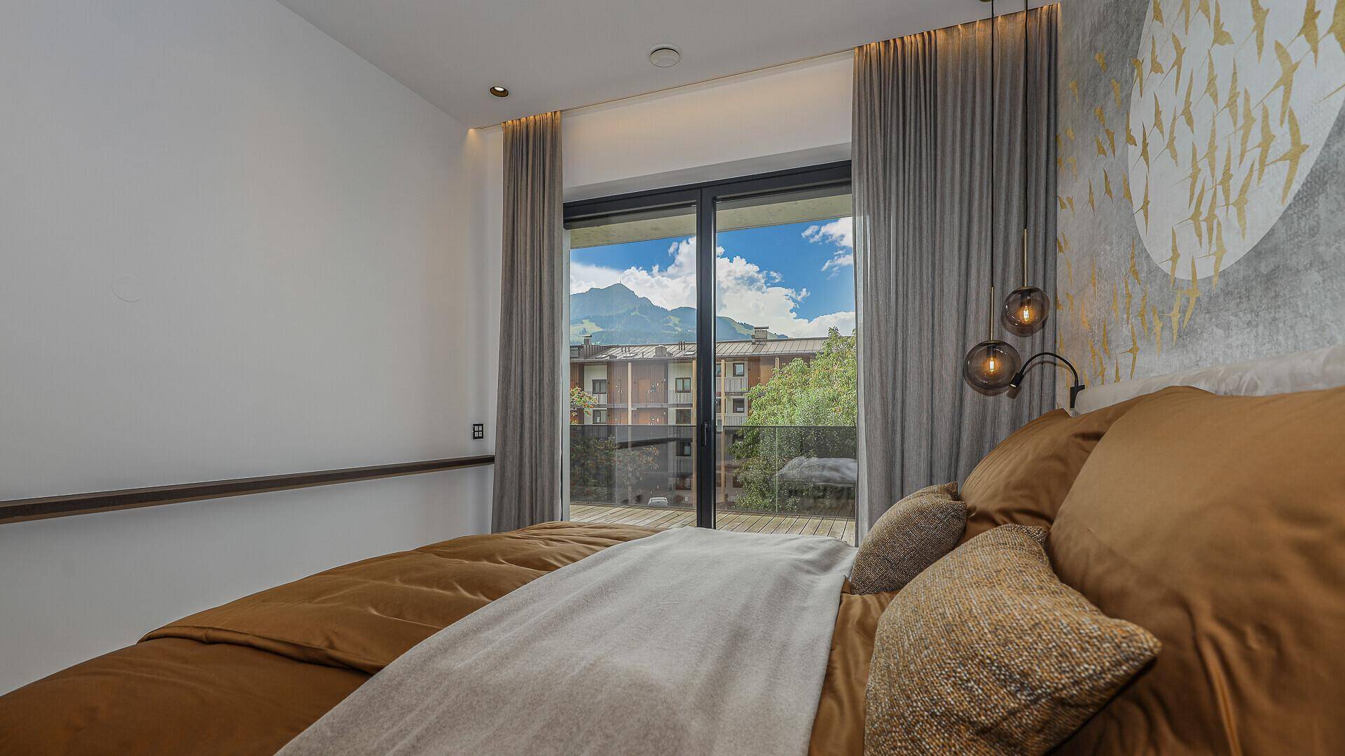 Schlafzimmer mit Bergblick, großen Fenstern und stilvoller Wanddekoration.