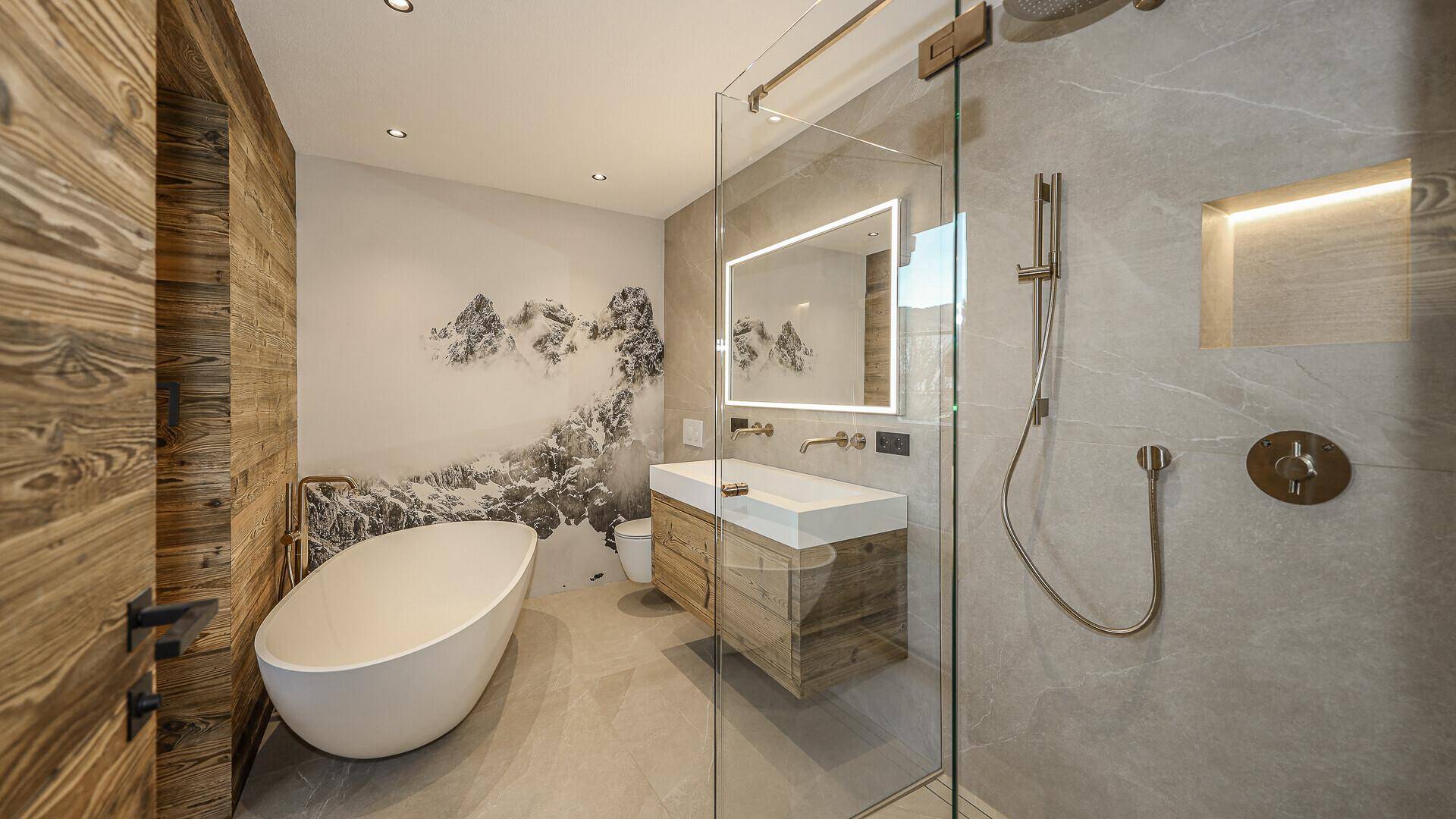 Elegantes Badezimmer mit großer Dusche, freistehender Badewanne und Wandbild mit Bergmotiv.