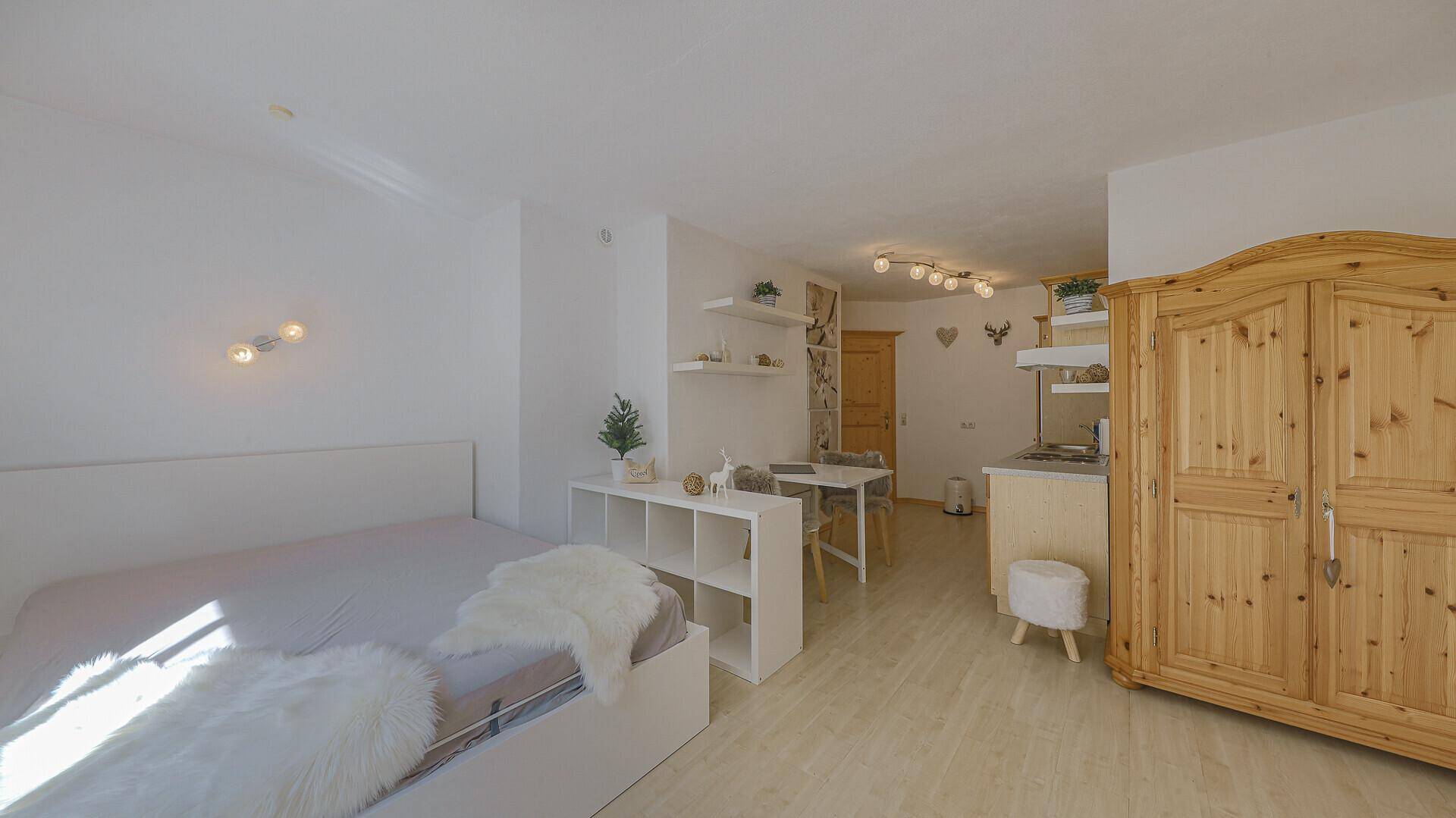 Gemütliches Studio-Apartment mit Schlafbereich, Essplatz und kleiner Küchenzeile.