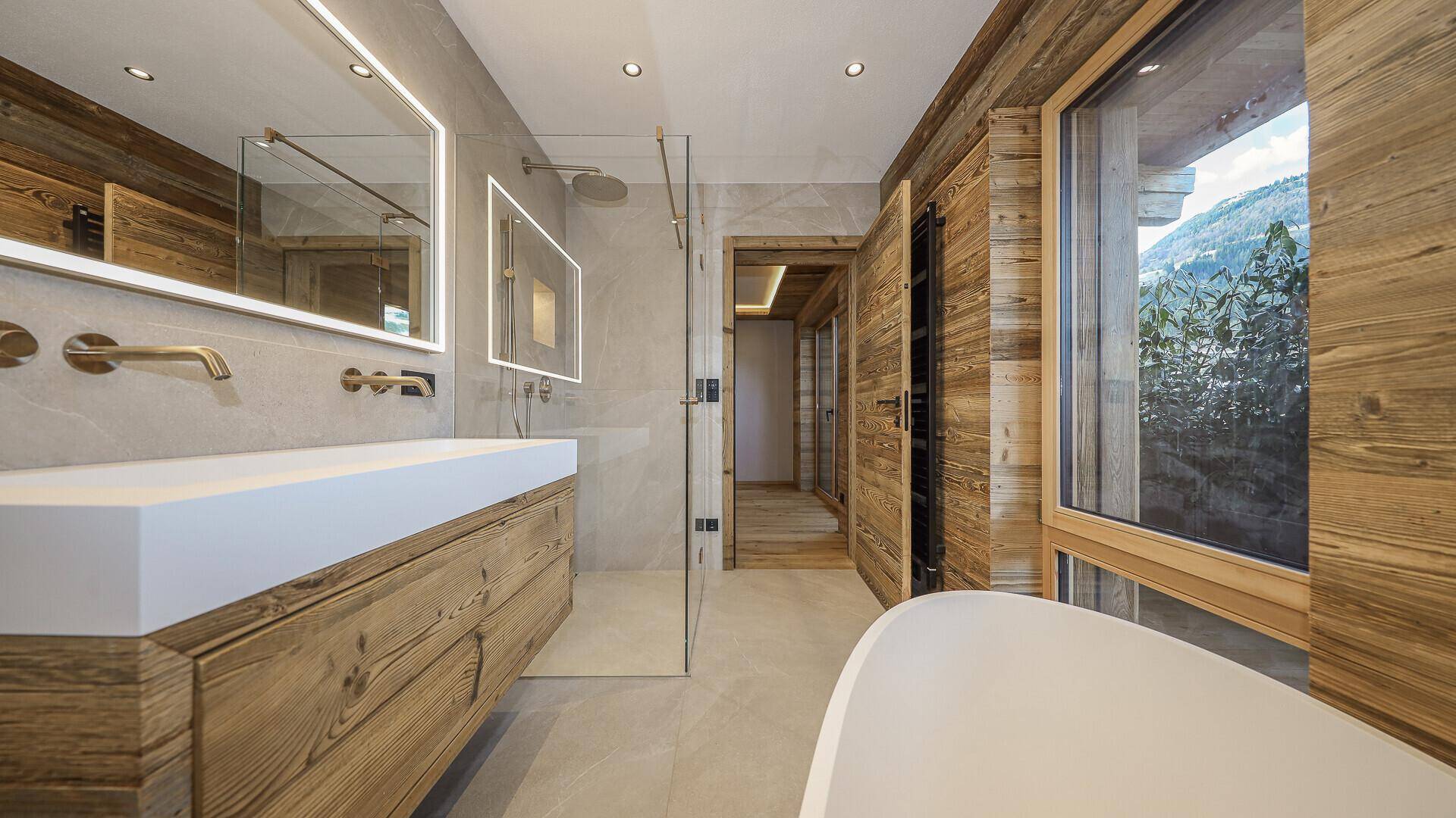 Modernes Badezimmer mit freistehender Badewanne, begehbarer Dusche und Holzdetails.