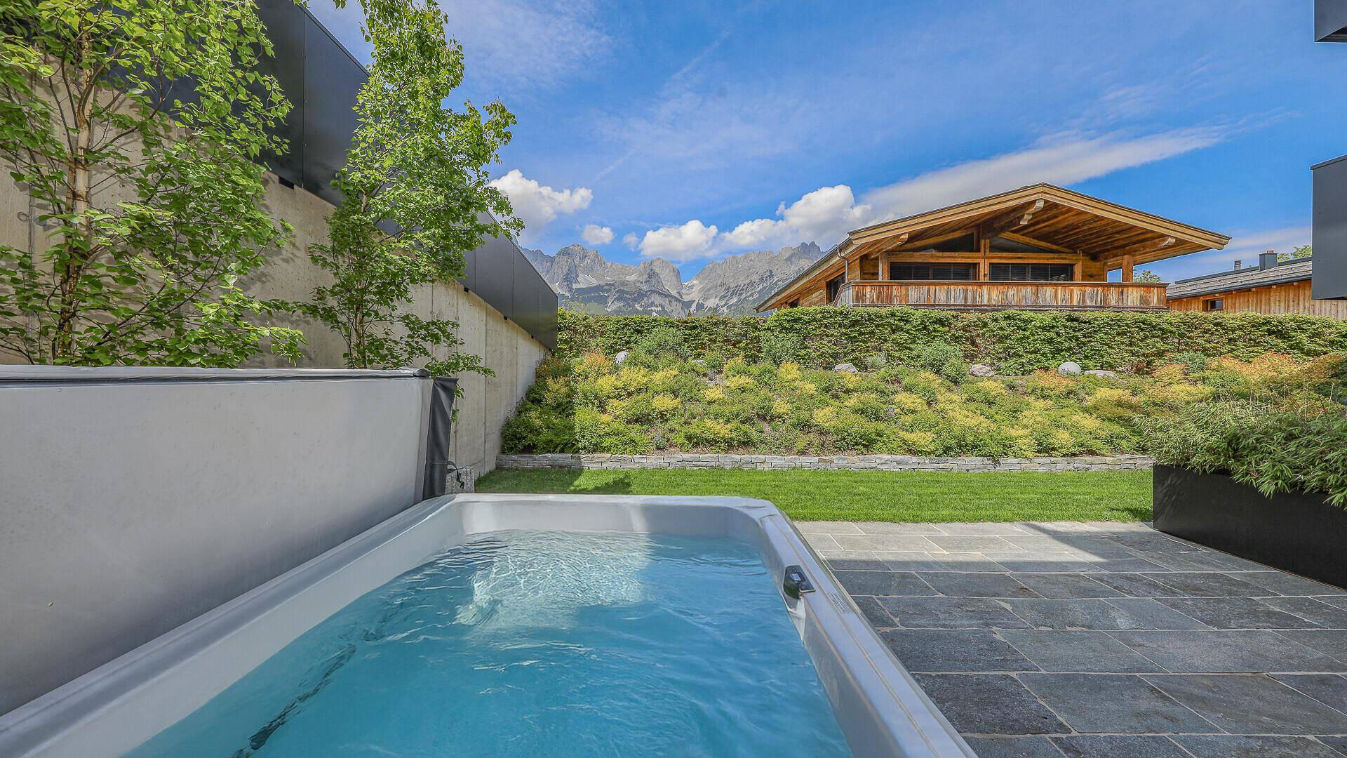 Entspannender Whirlpool auf der Terrasse mit Blick auf die umliegende Berglandschaft.