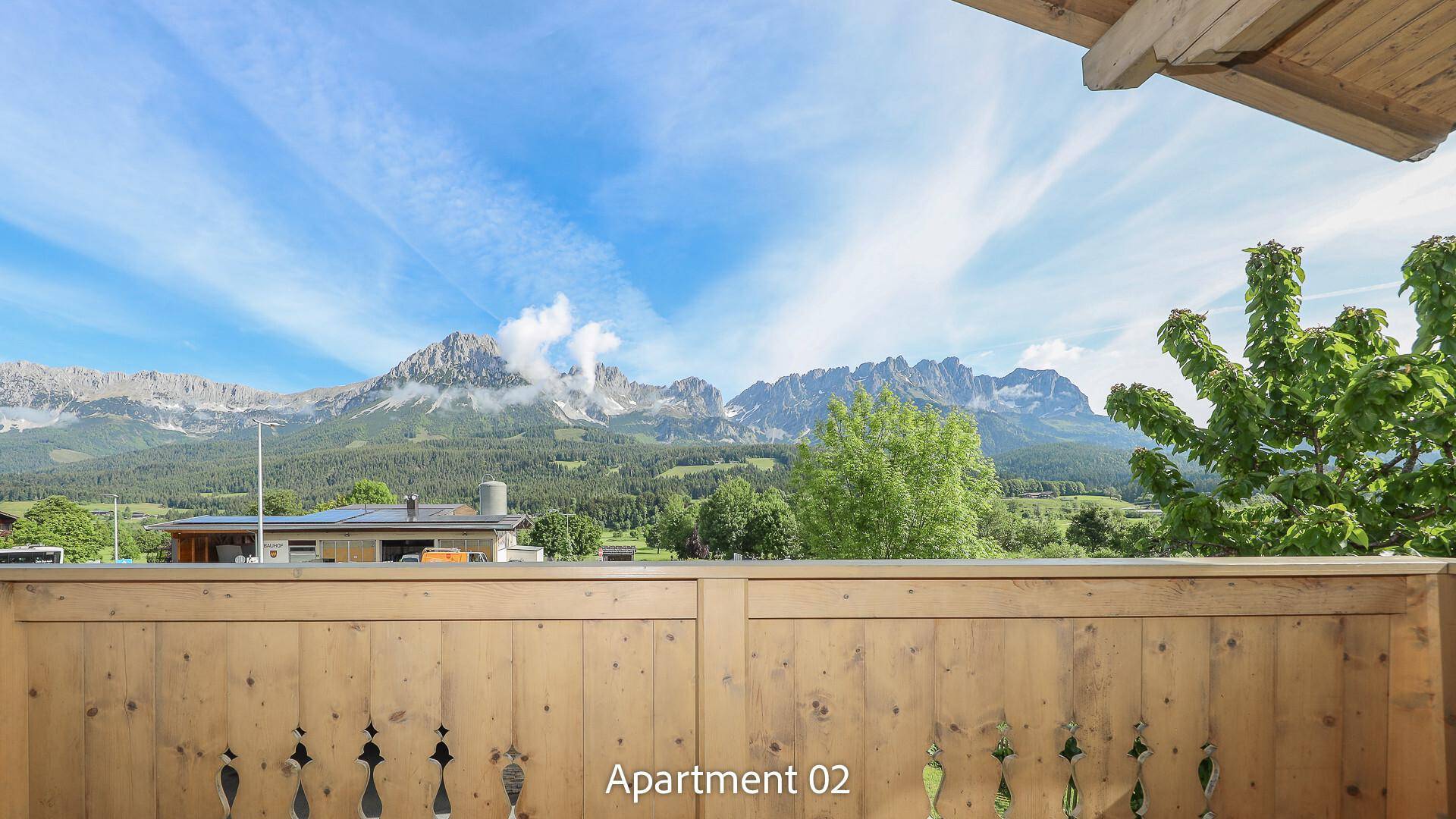 Balkon mit Holzgeländer und weitem Blick auf die beeindruckende Berglandschaft.