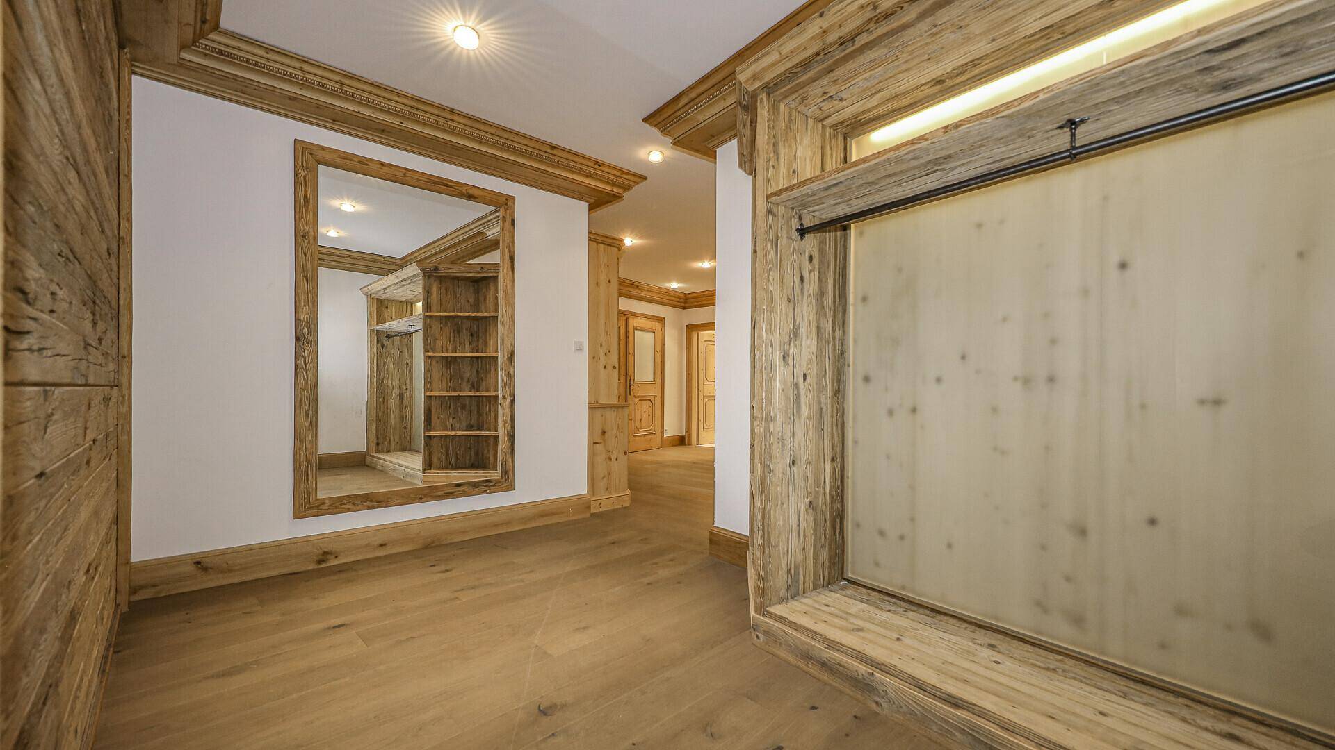 Flur mit Holzwänden, großem Spiegel und einer Schiebetür aus Milchglas.