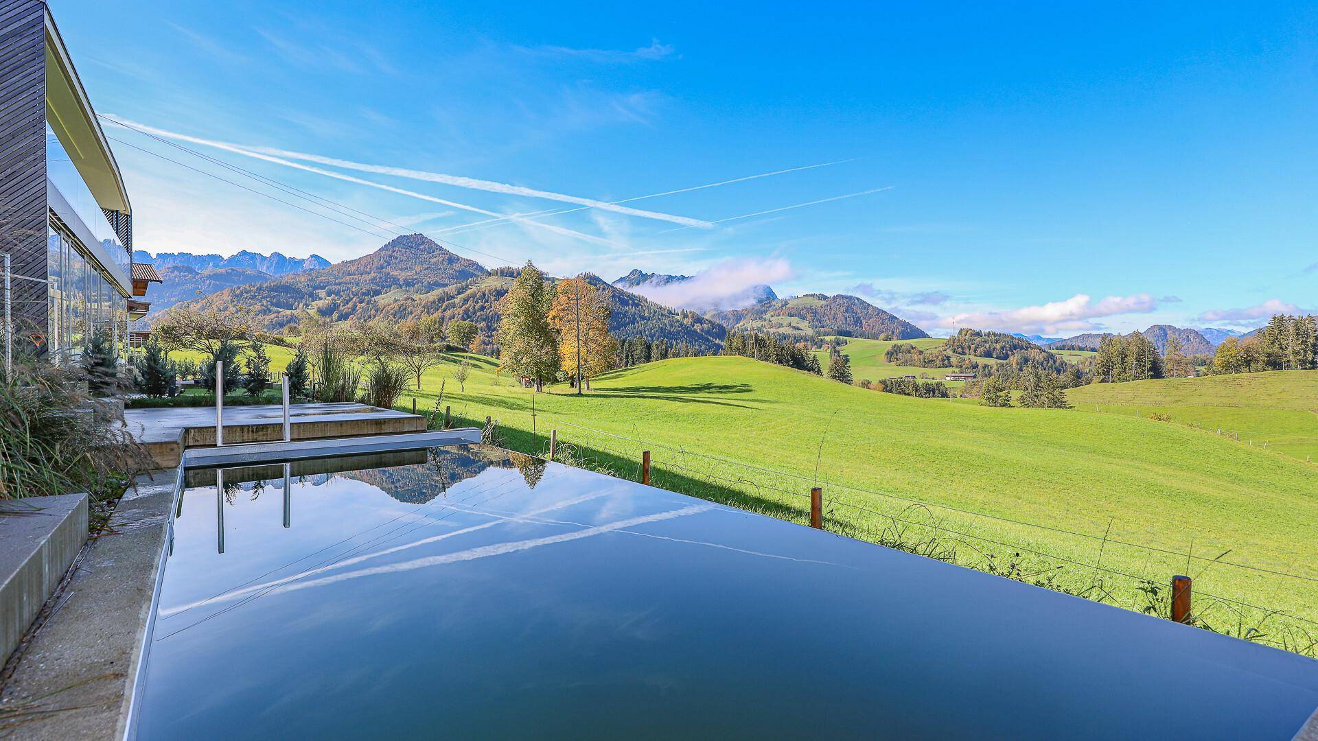 Infinity-Pool mit spiegelnder Wasseroberfläche und atemberaubendem Bergblick.