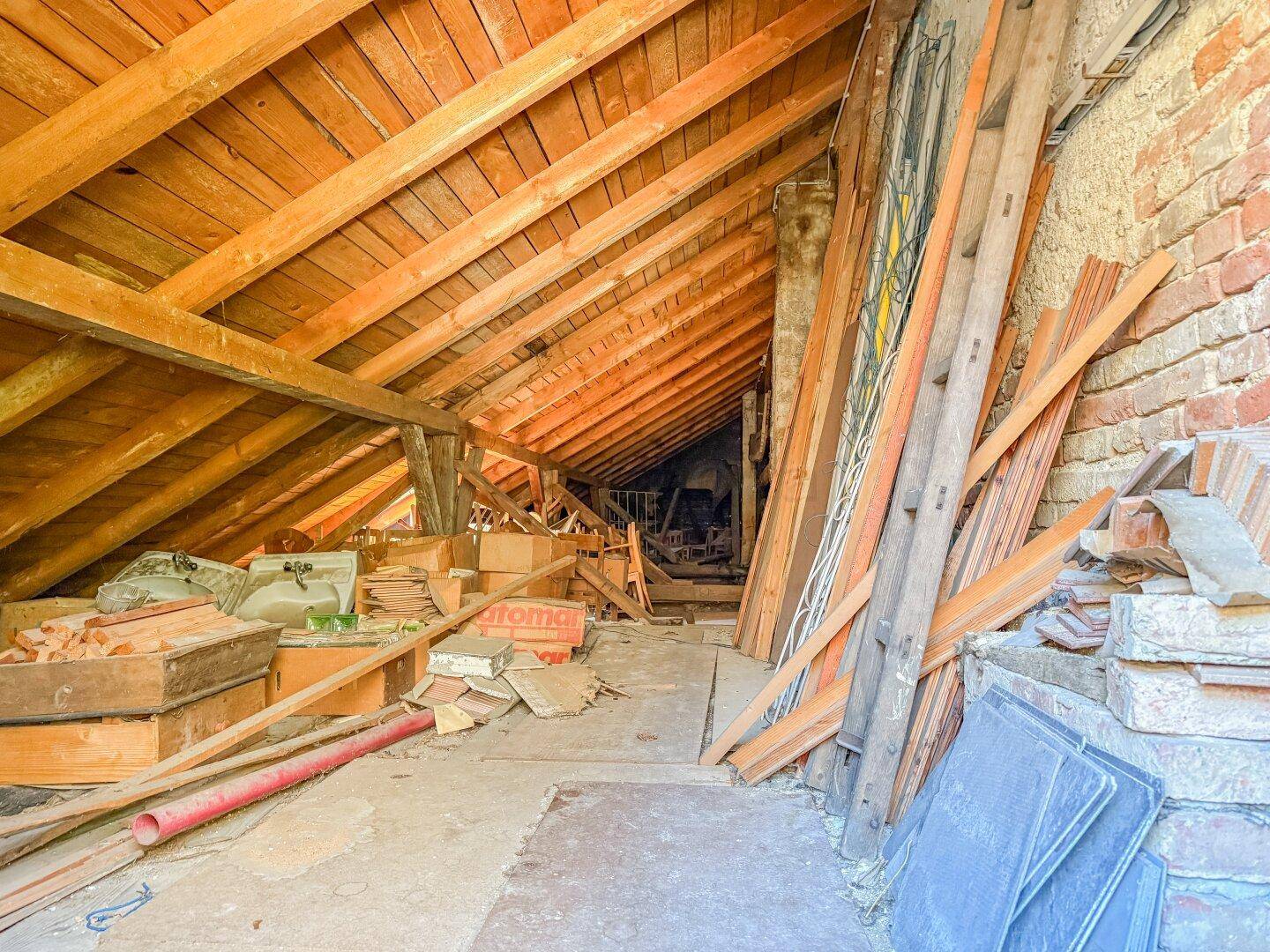 Geräumiger Dachboden mit freiliegenden Holzbalken und Lagerflächen.