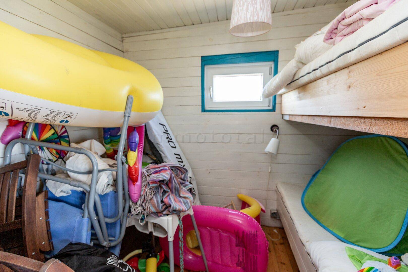 Schlafzimmer mit Etagenbett und Stauraum für Spielzeug und aufblasbare Gegenstände.