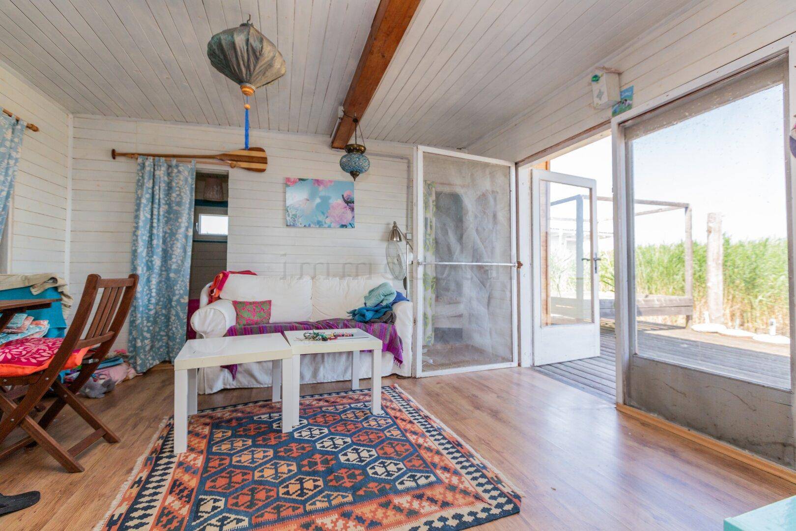 Heller Wohnbereich mit Zugang zur Terrasse und Blick ins Grüne, ausgestattet mit Sofa.