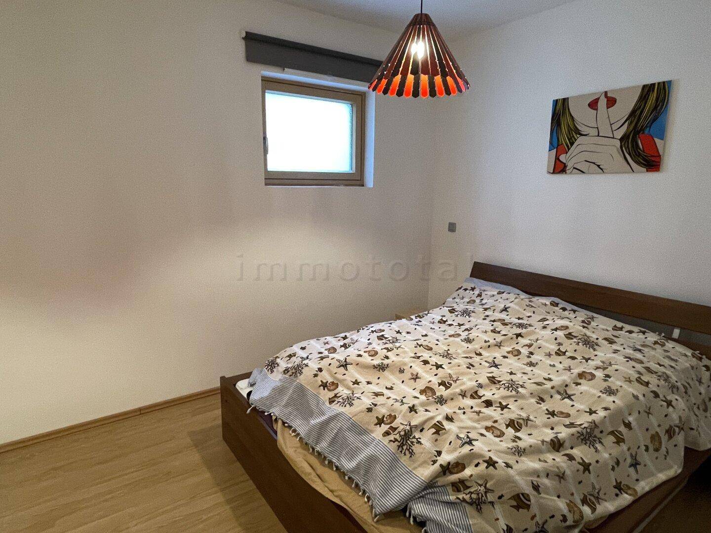 Gemütliches Schlafzimmer mit Doppelbett und Fenster, hell und einladend.