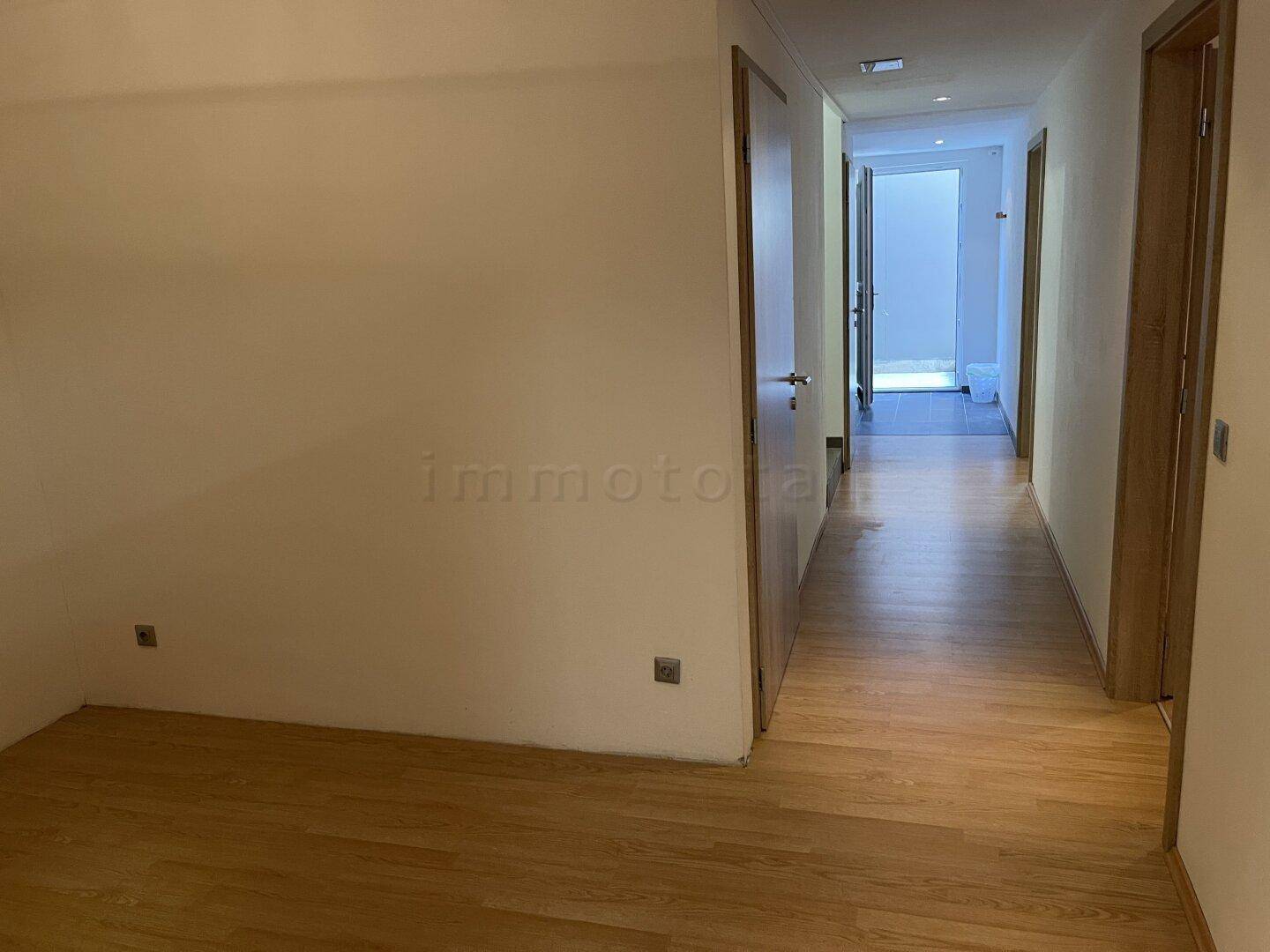 Langer Flur mit Holzboden, der zu den verschiedenen Zimmern führt.