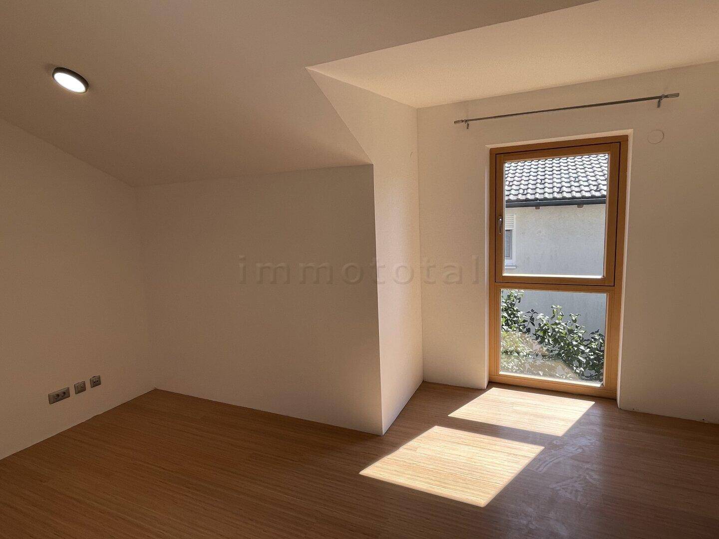 Helles Zimmer mit Holzboden und Fenster, ideal als Schlaf- oder Arbeitszimmer.