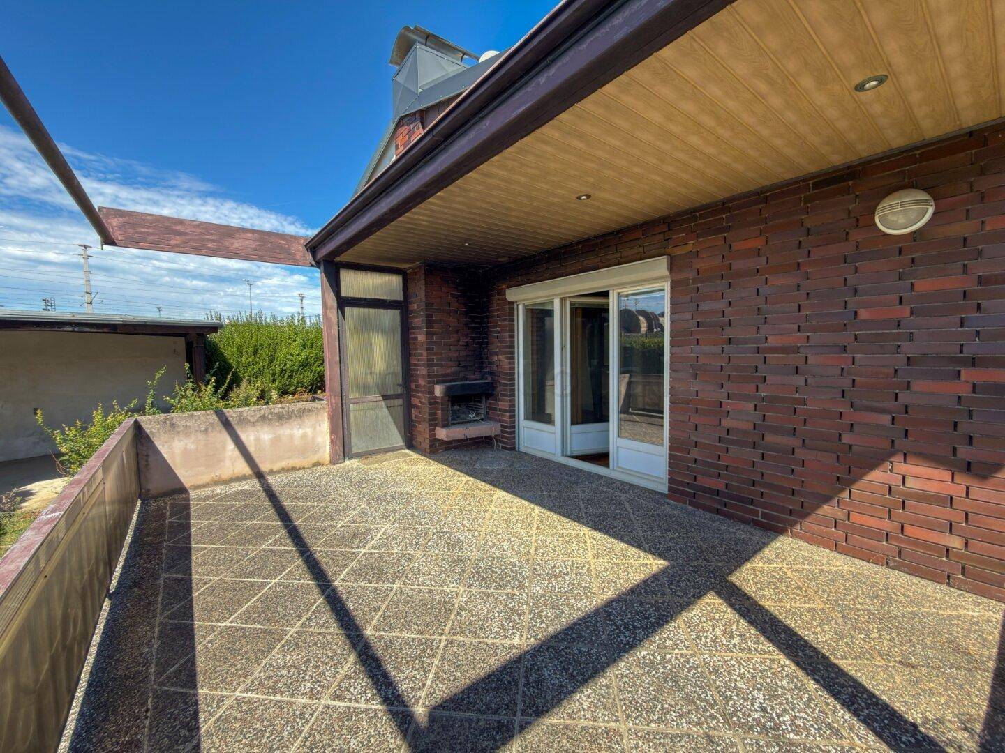 Großer Balkon mit Fliesenboden und Ziegelwand, ideal für entspannte Stunden im Freien.