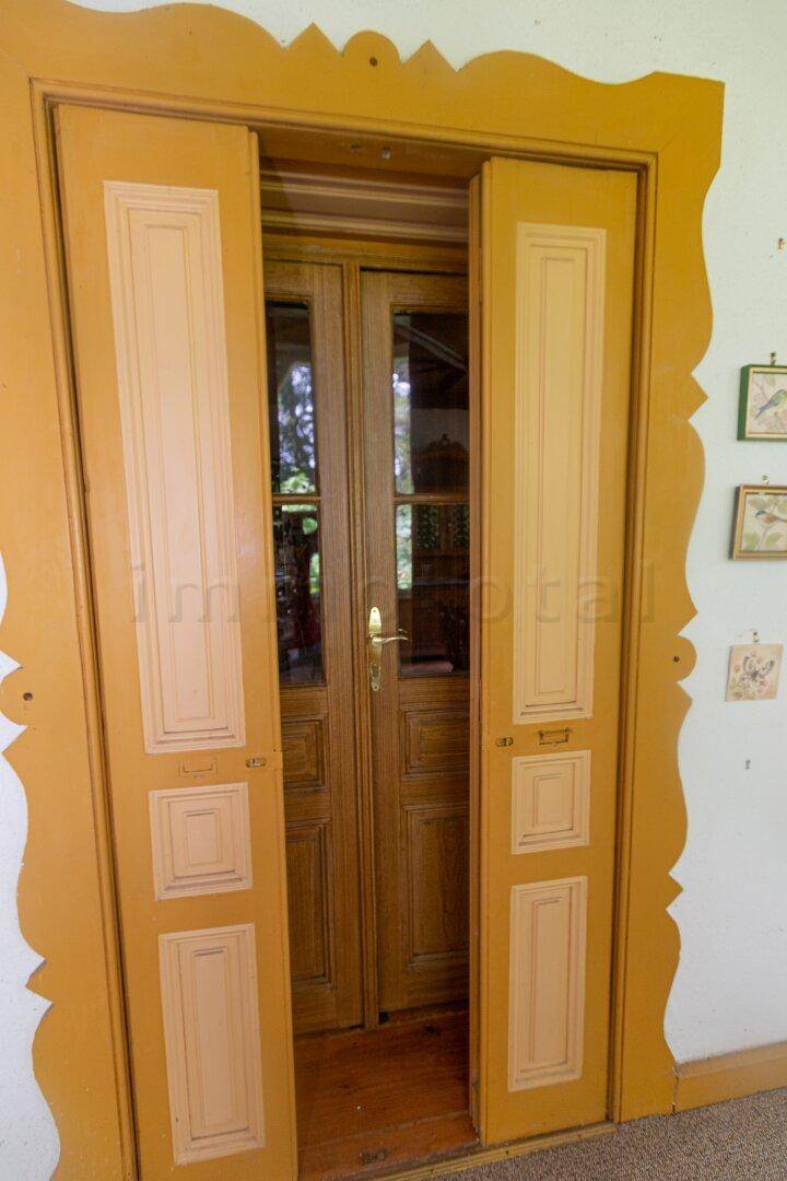 Detailansicht einer traditionellen Holztür mit Glaseinsätzen und dekorativem Rahmen.