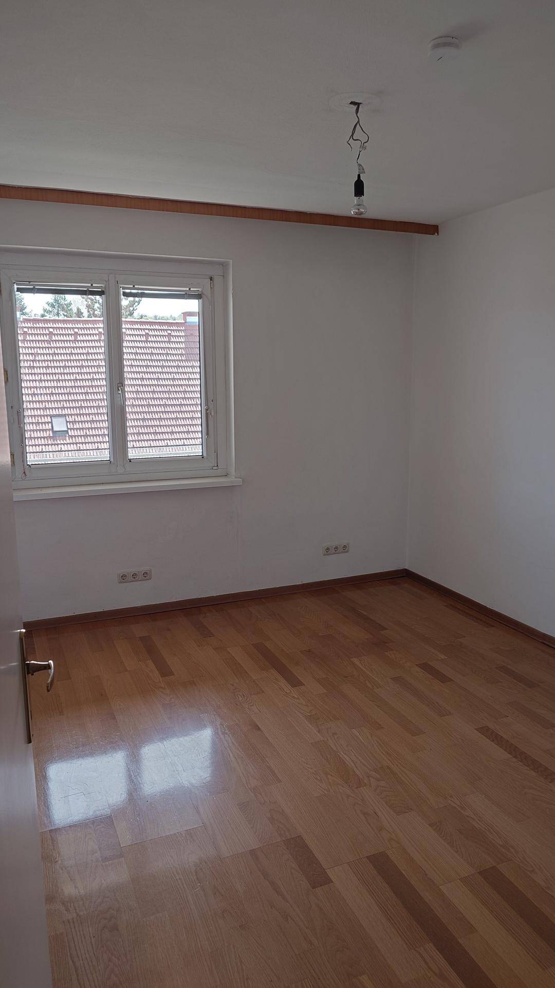 Heller Raum mit Parkettboden und Fenster, bereit zur individuellen Gestaltung.